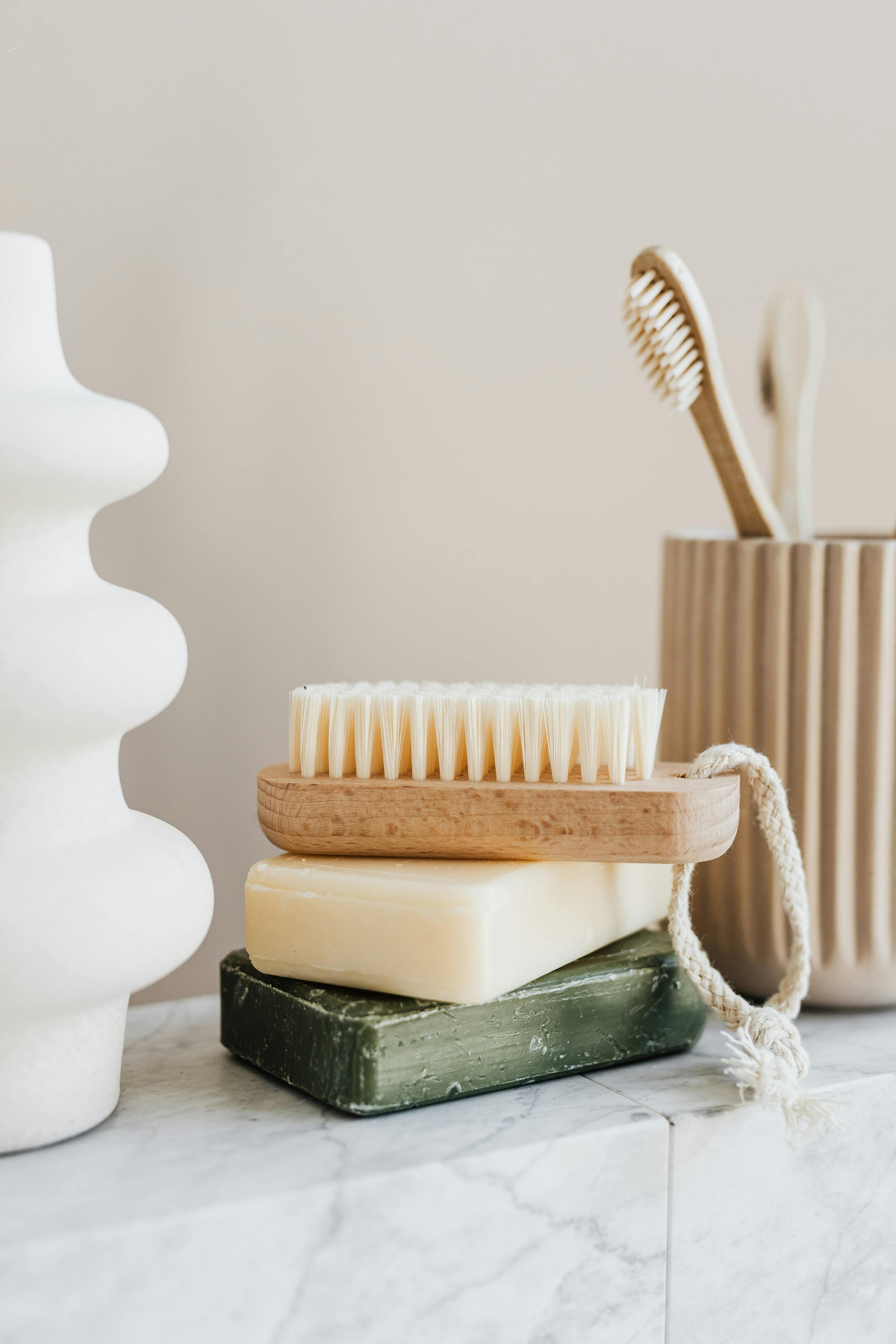 Eco-friendly bathroom items, including a wooden toothbrush and soap bars