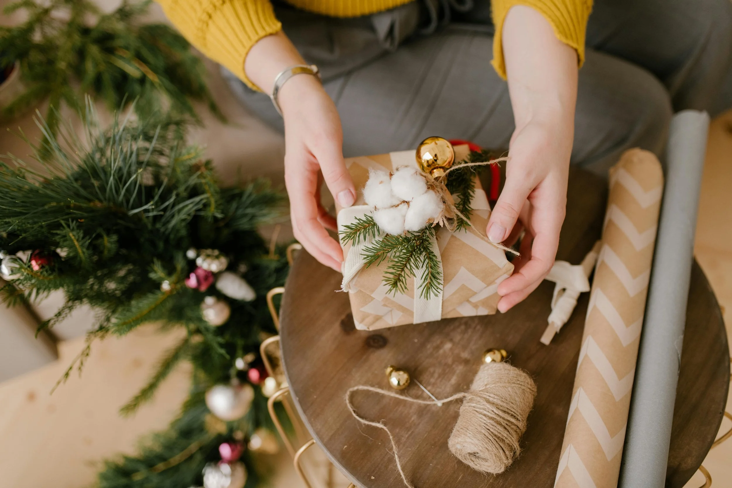 A woman wrapping a Christmas gift with eco-friendly wrapping paper
