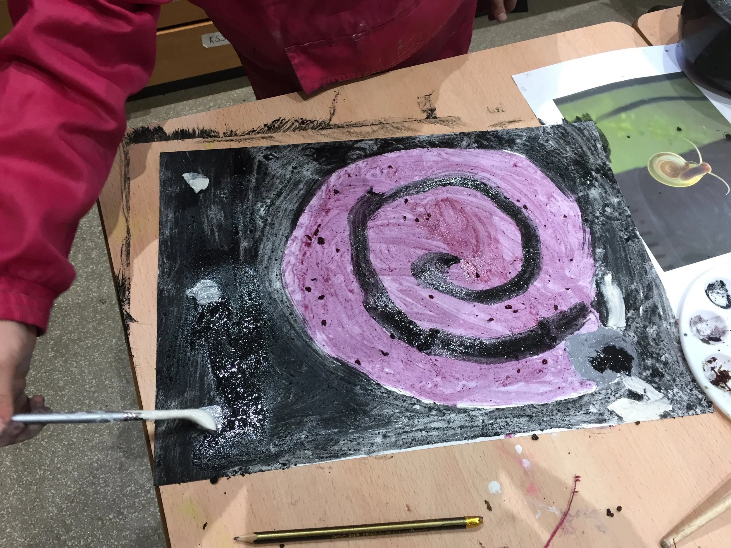 Young maker painting from pounded natural materials: chalk, charcoal & berry ink