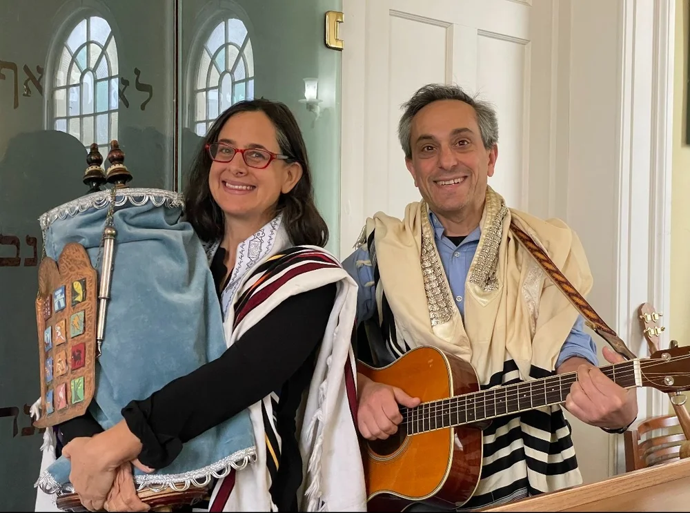 Two rabbis in prayer shawls, one holding a guitar, in the PCS sanctuary.