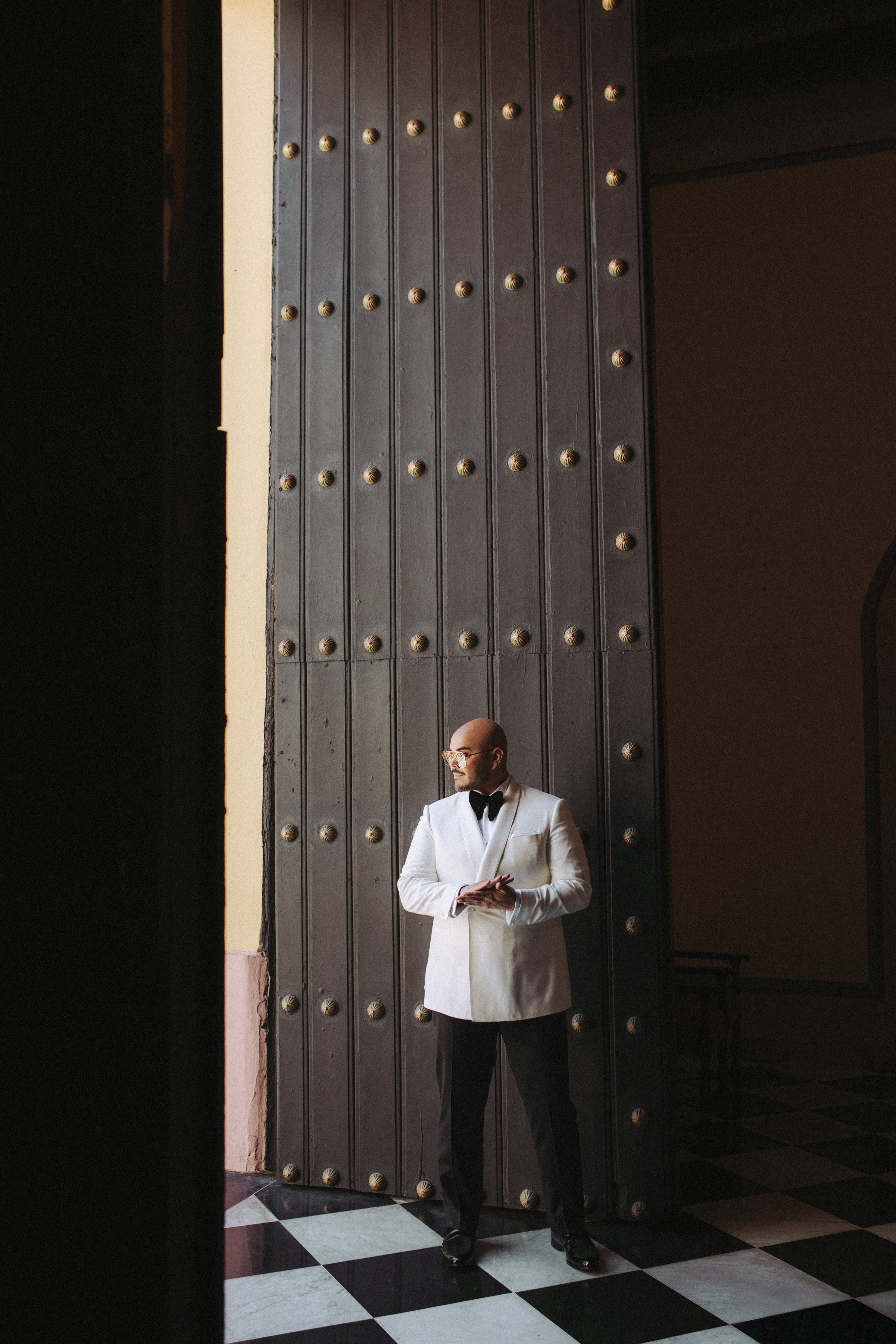 Hotel El Convento groom photos doorway R Douglas Custom Suit white jacket black pants David Garibaldi