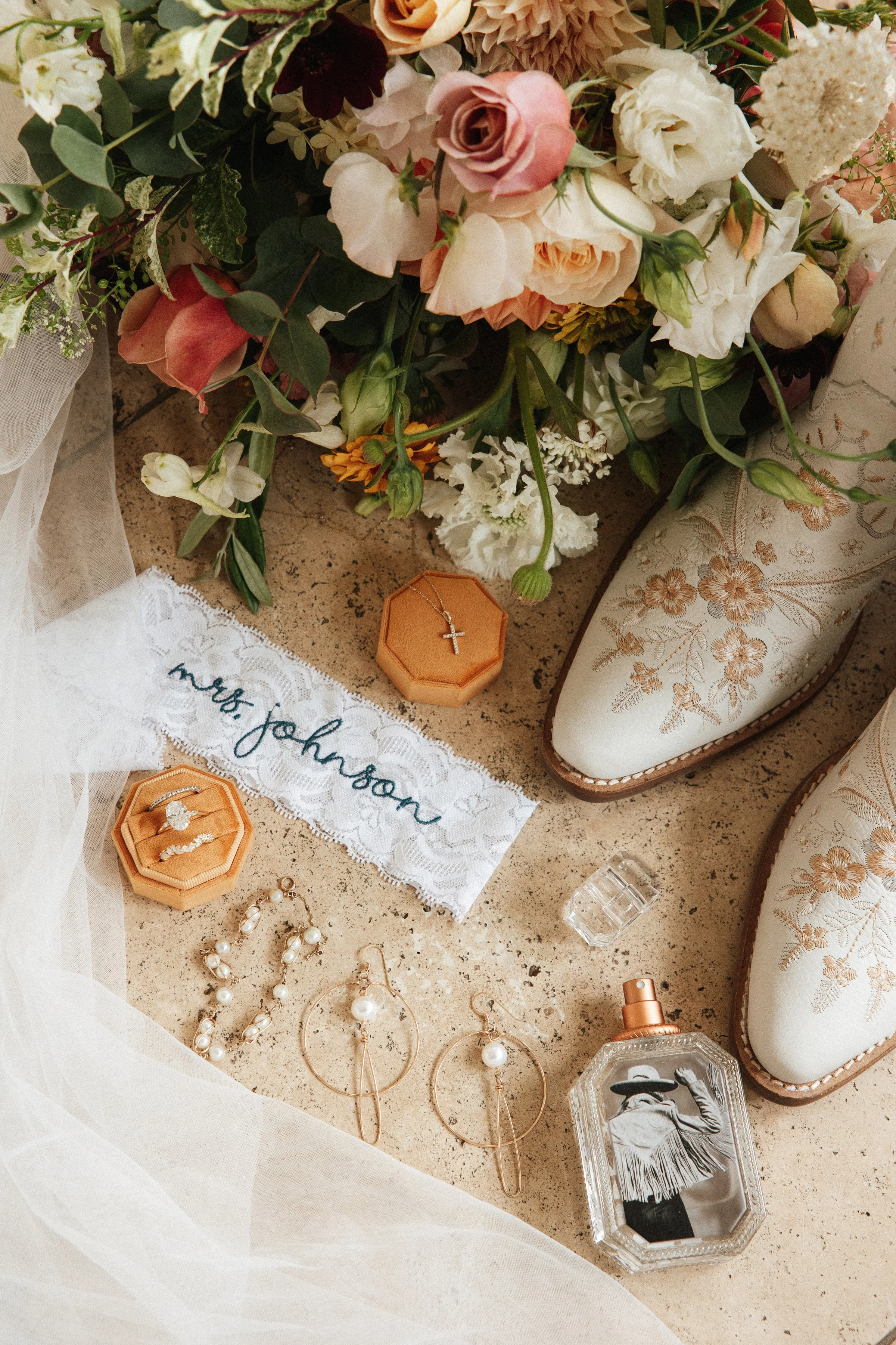 Flat lay wedding bridal details warm summer colors and white cowboy boots