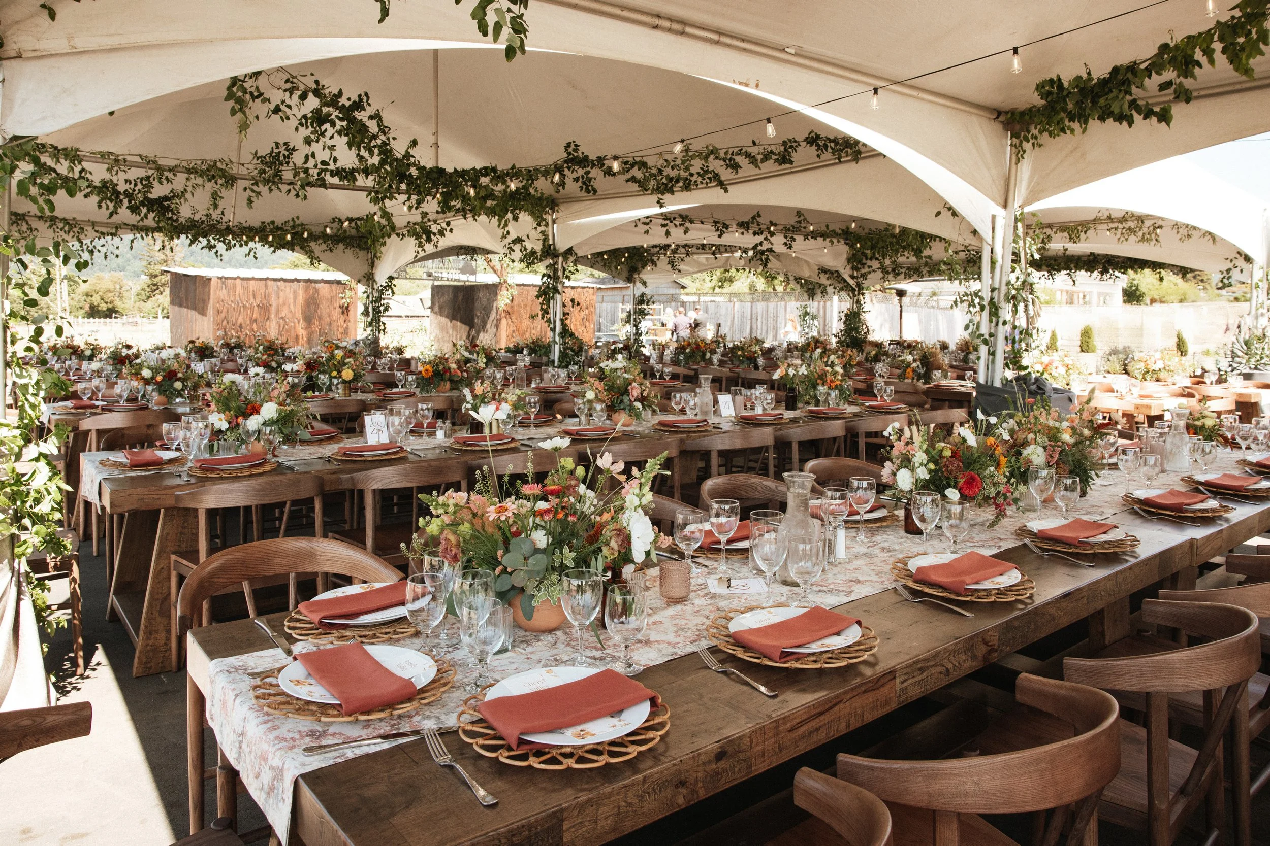 Private estate tent reception with lots of greenery and garland warm summer florals roses wild flowers