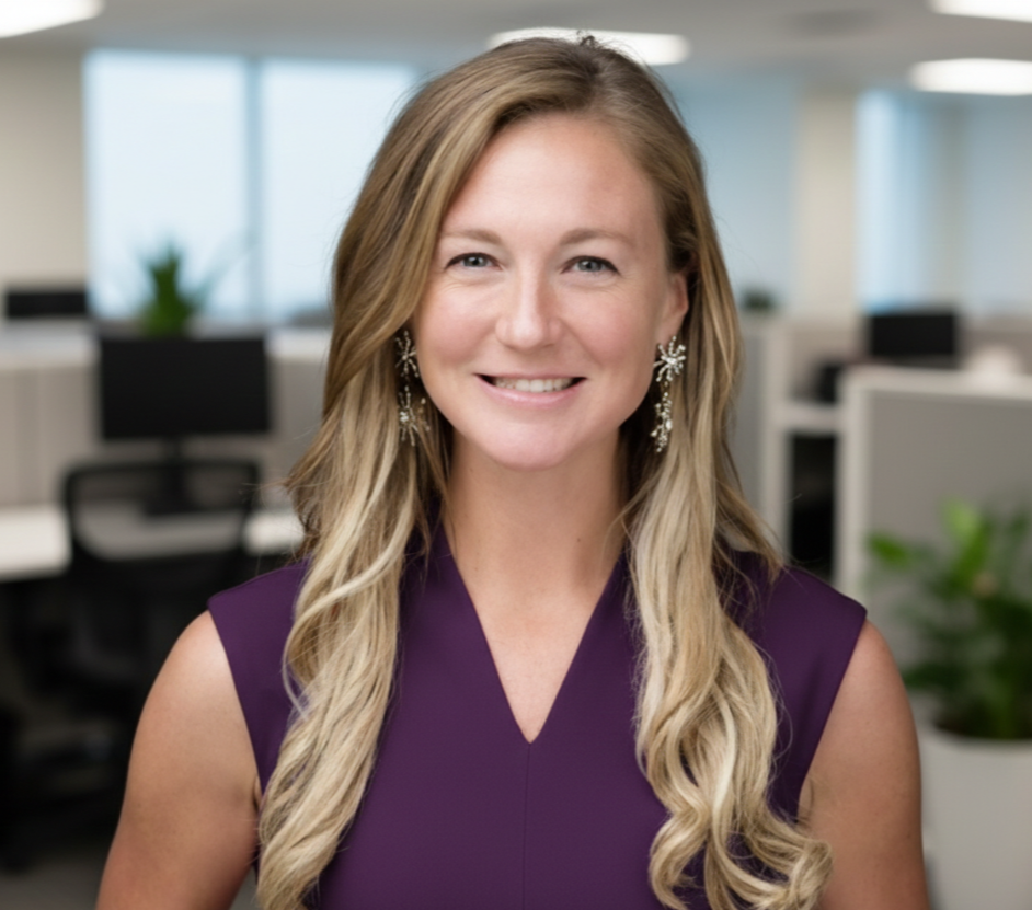 Headshot of a woman with long blonde hair, wearing earrings and a sleeveless red top, smiling against a gray background.