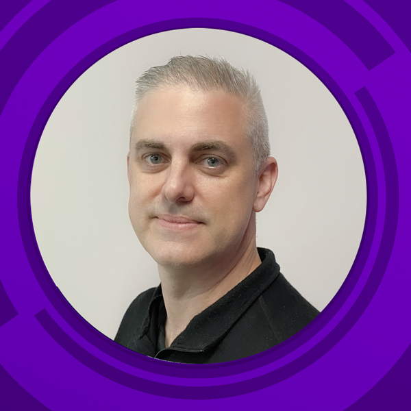 Headshot of a man with short, light gray hair, blue eyes, and fair skin, wearing a black polo shirt, against a plain white background with a purple graphic border.