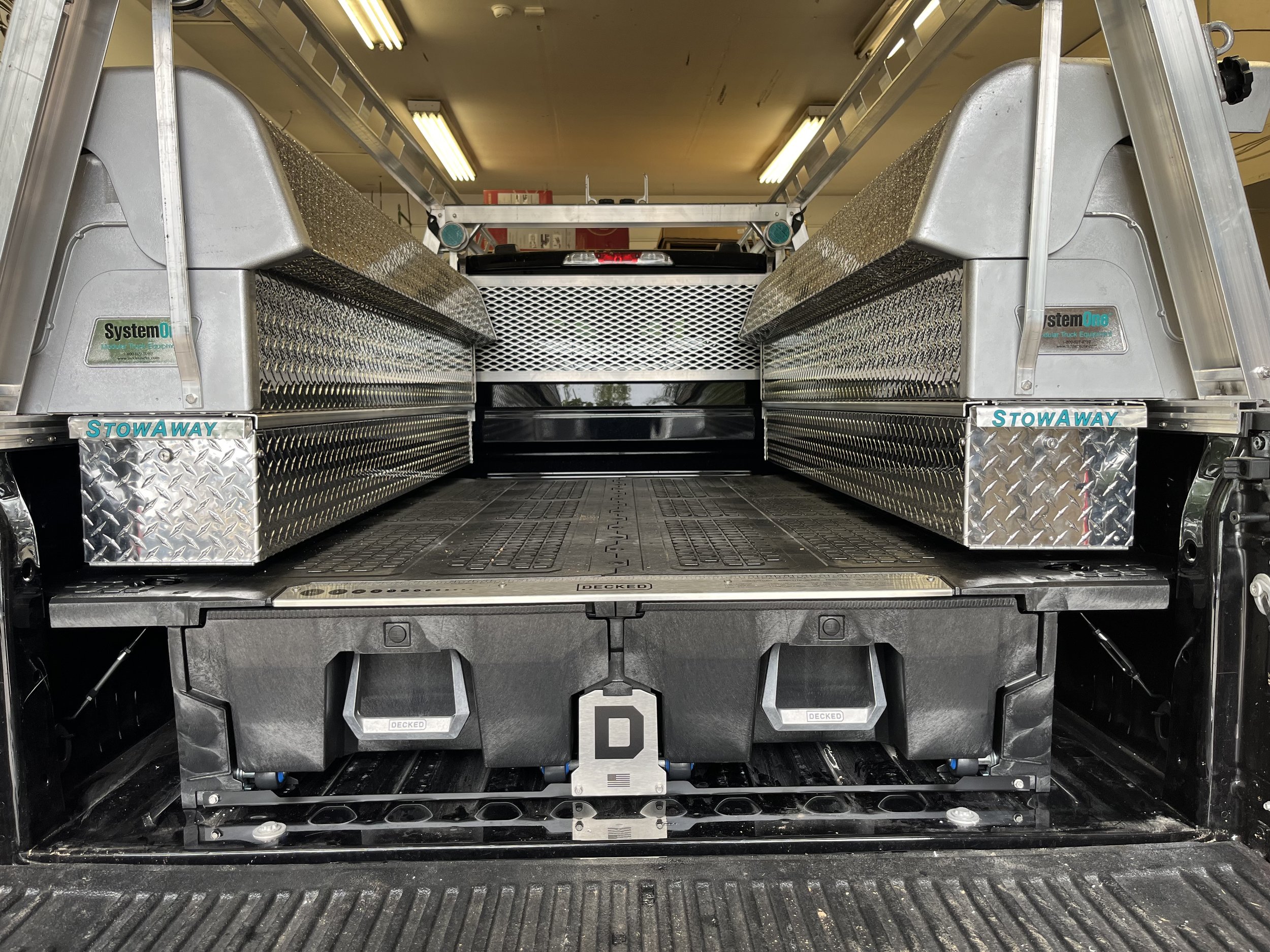 The image shows the rear cargo area of a fire truck with storage compartments, metallic toolboxes, and a flatLoading platform.