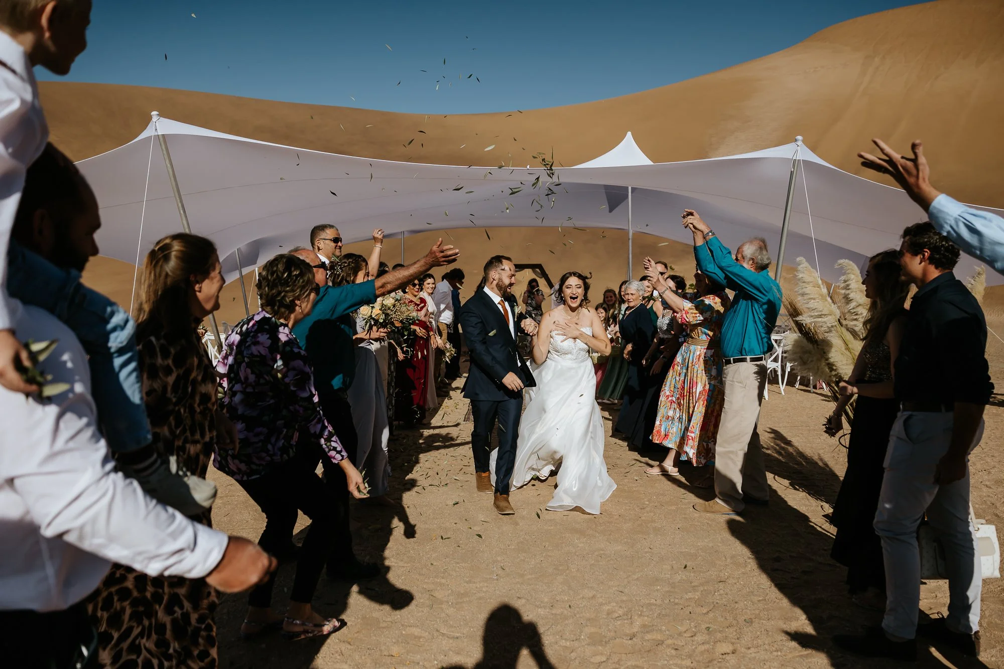 Bride and groom celebrating with wedding guests in the Namib desert
