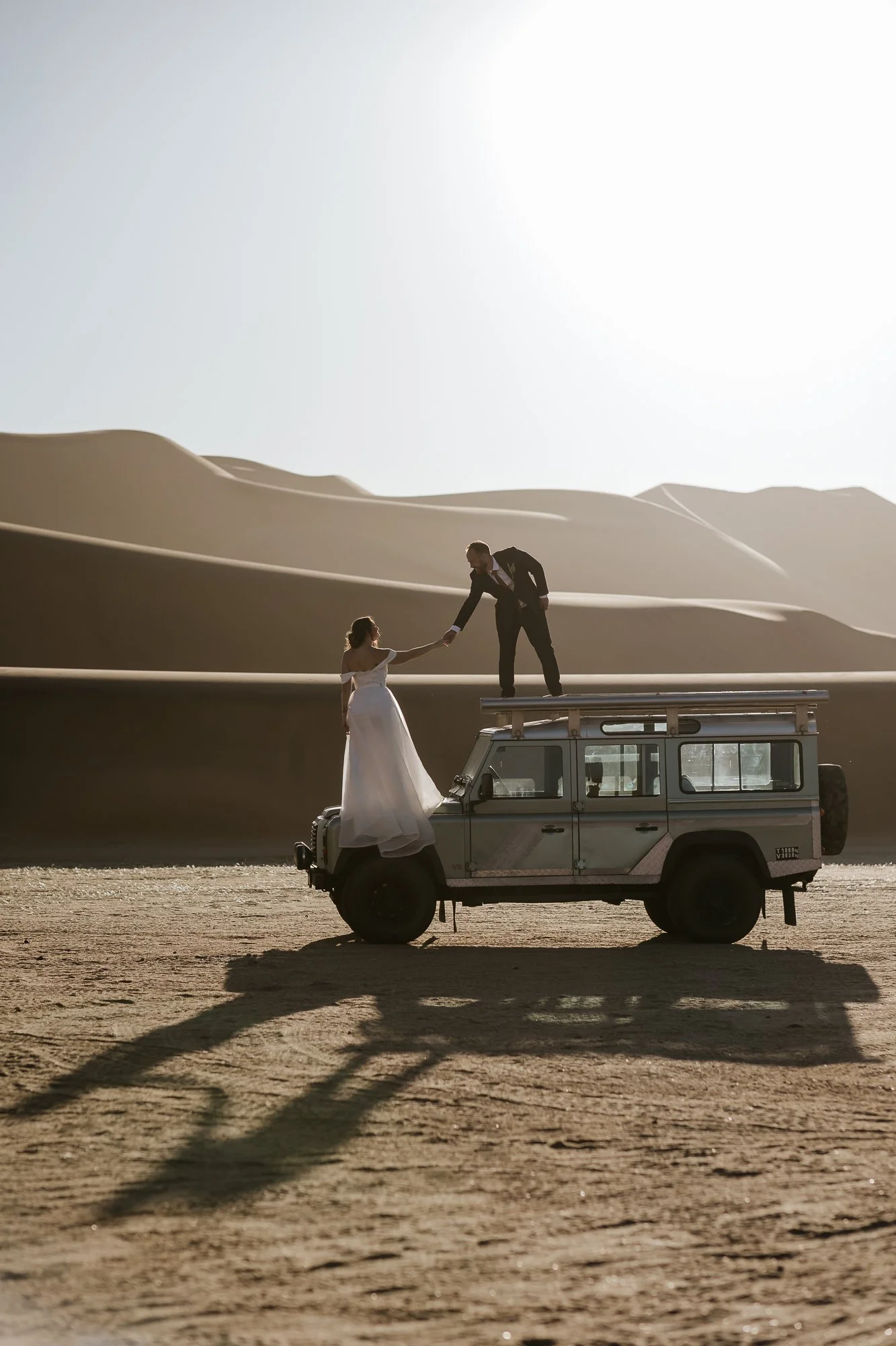 Bride and groom with Land Rover among the dunes in Namibia