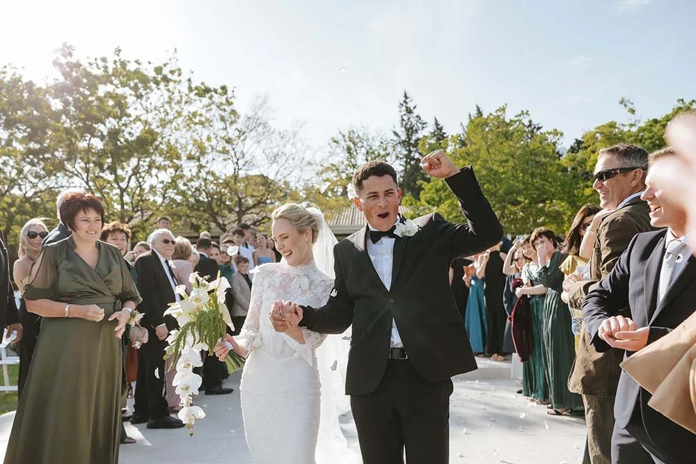 Bride and groom celebrating through wedding confetti