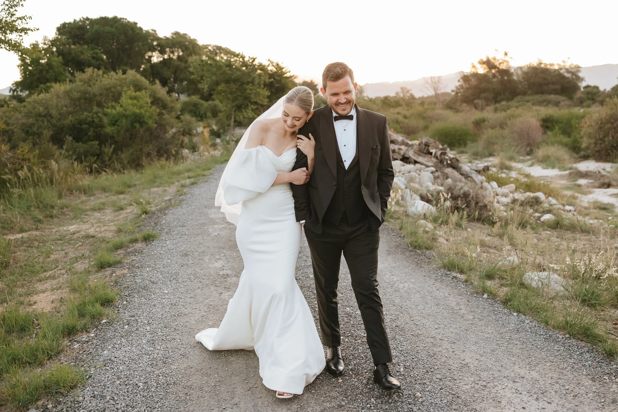 Bride and groom walking together at golden hour photographed by Cape Town wedding photographer Kobus Tollig