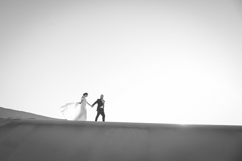 Bride and groom walking on a dune in Nambia