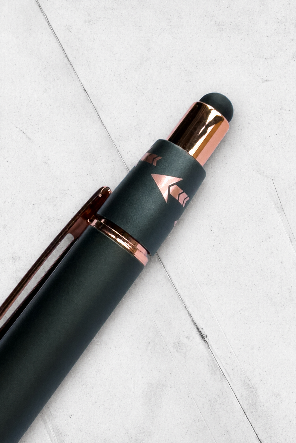 Rose-gold stylus on creased white paper.png