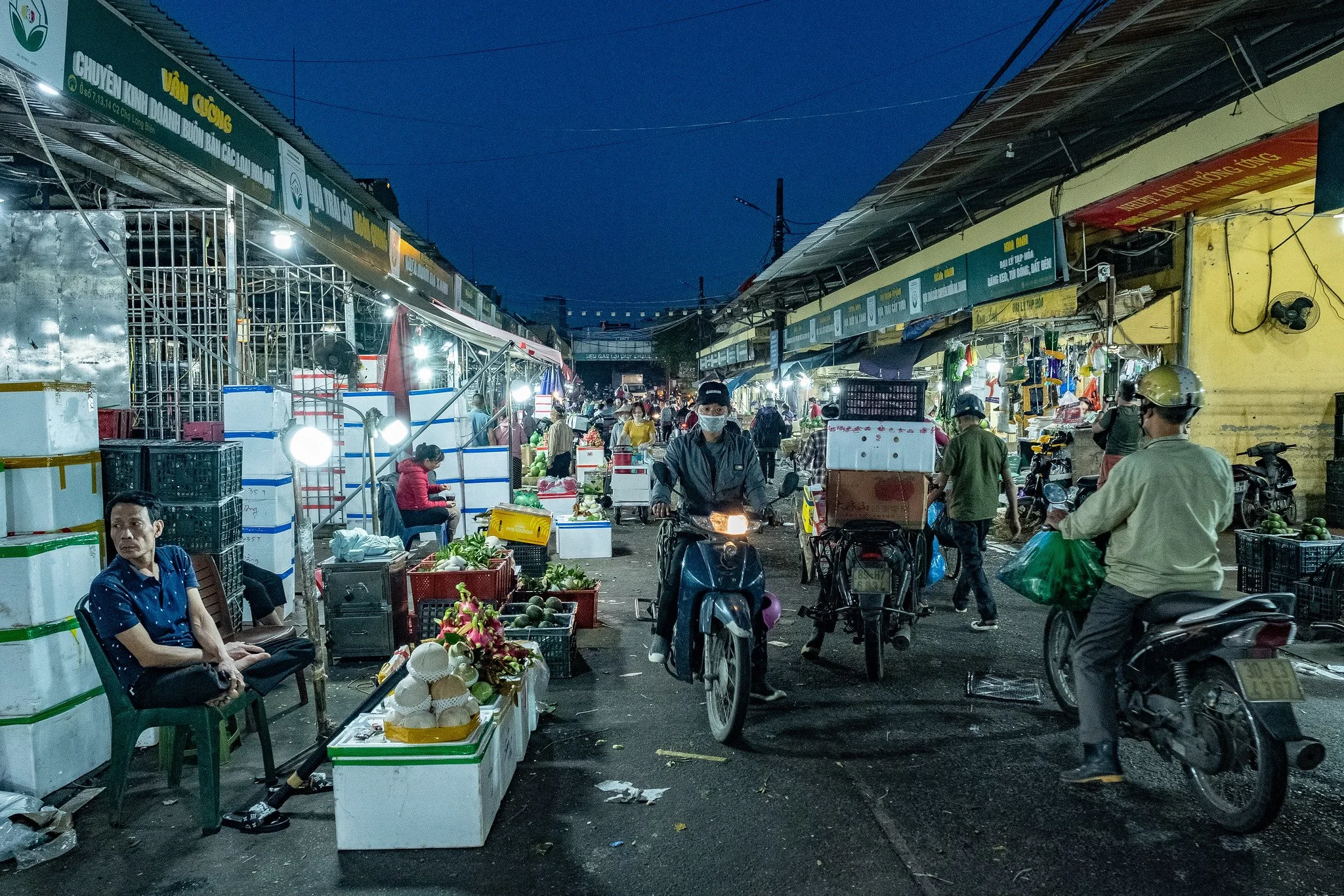 Motorbikes make their way through the market to pick up deliveries © Bob Plotkin