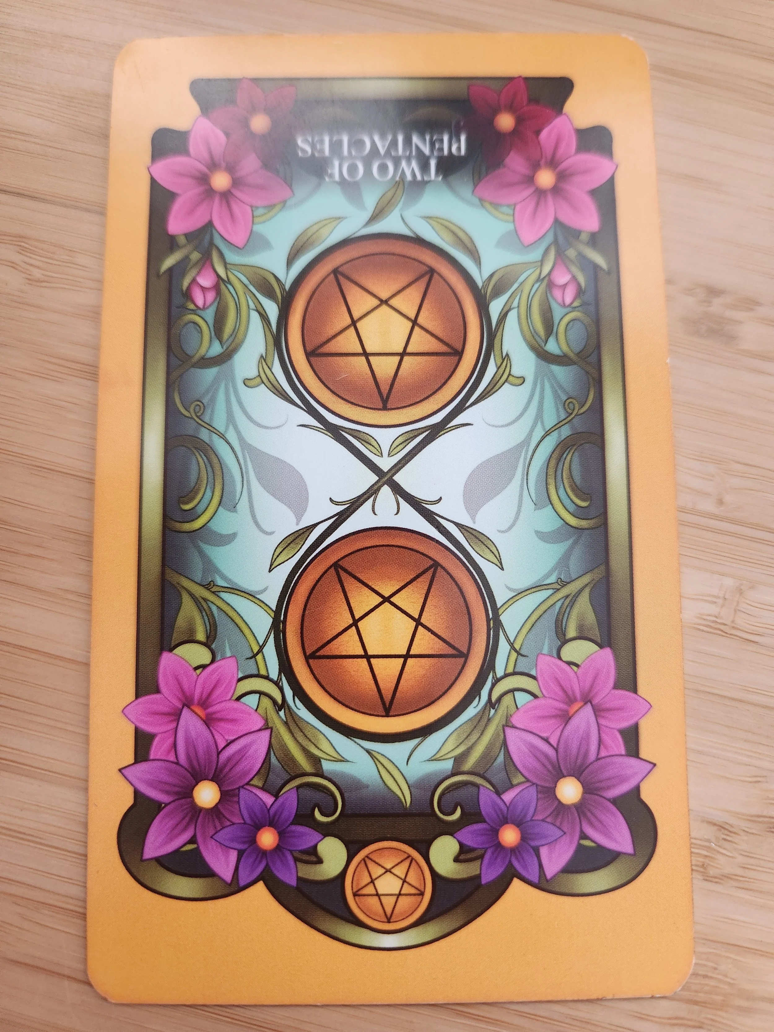 Two of Pentacles Reversed tarot card representing imbalance and the need for simplification