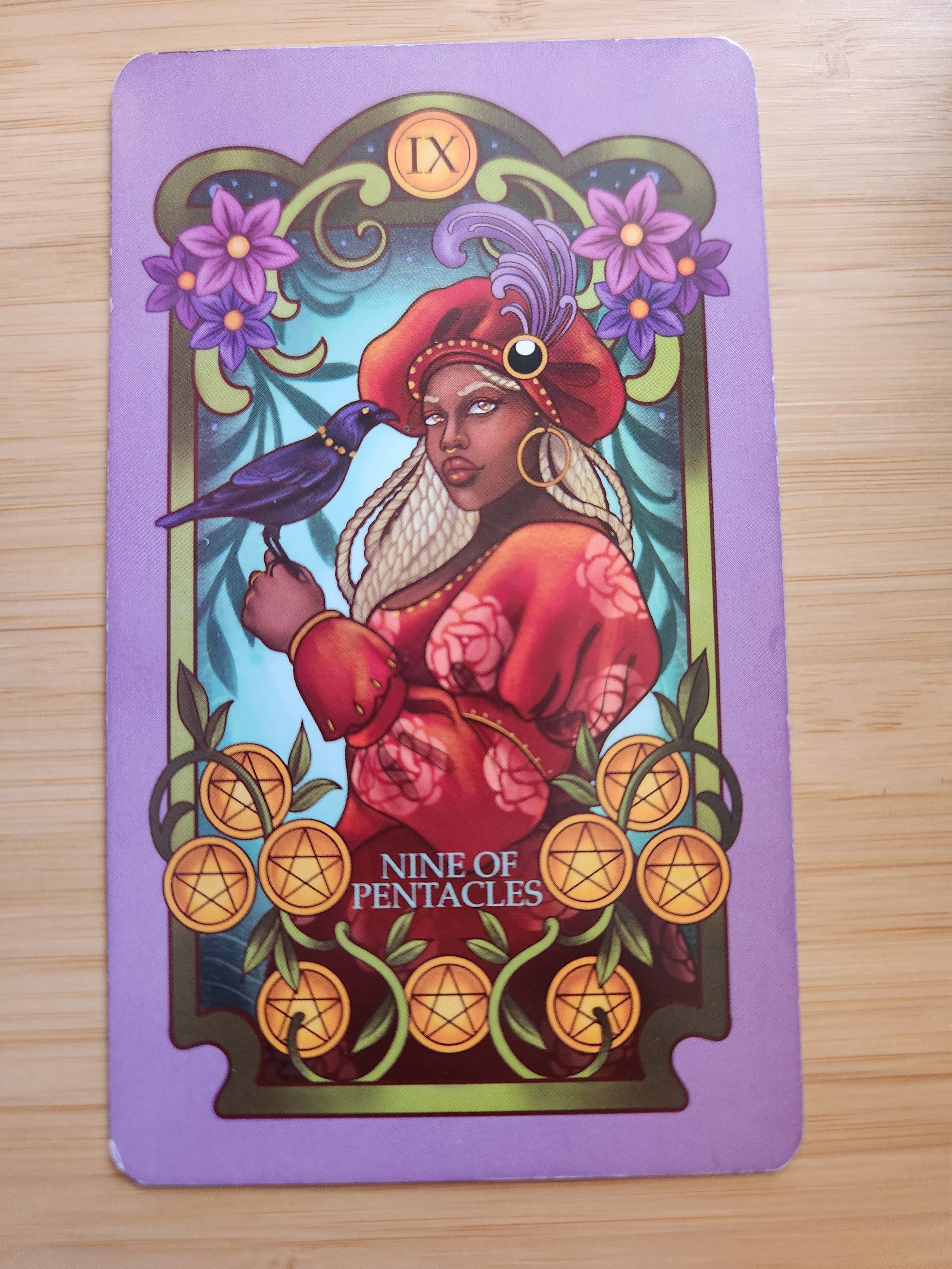 Nine of Pentacles tarot card with lush garden, birds, and elegant figure