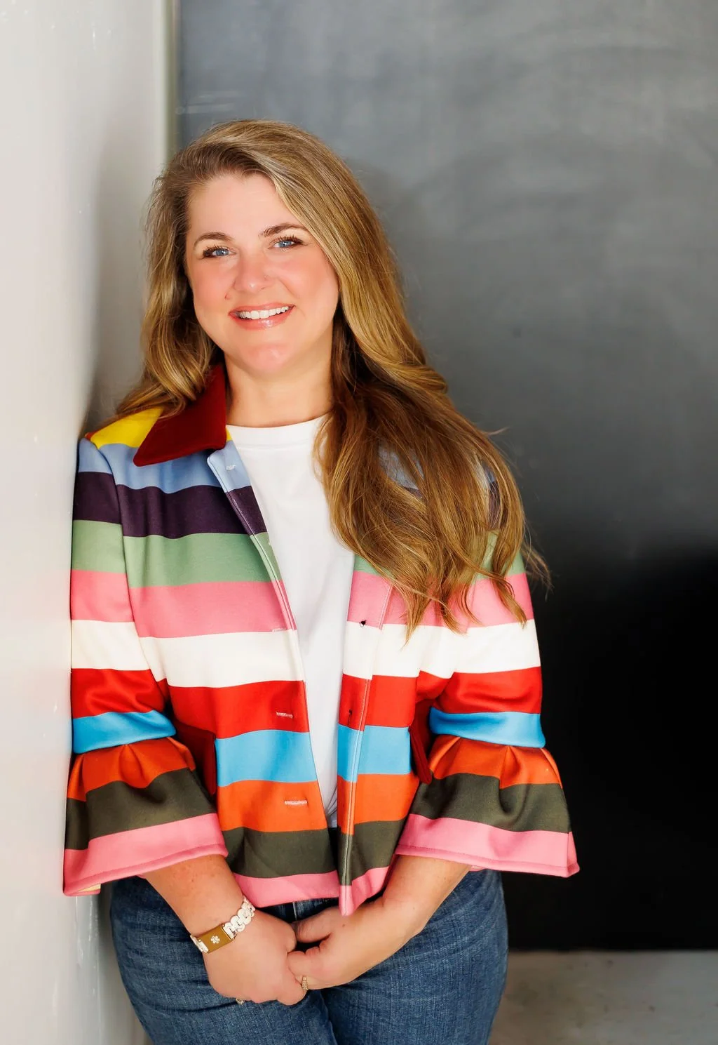Freelance Writer and Brand Strategist Brittany Shepard in a colorful striped blazer leaning against a wall
