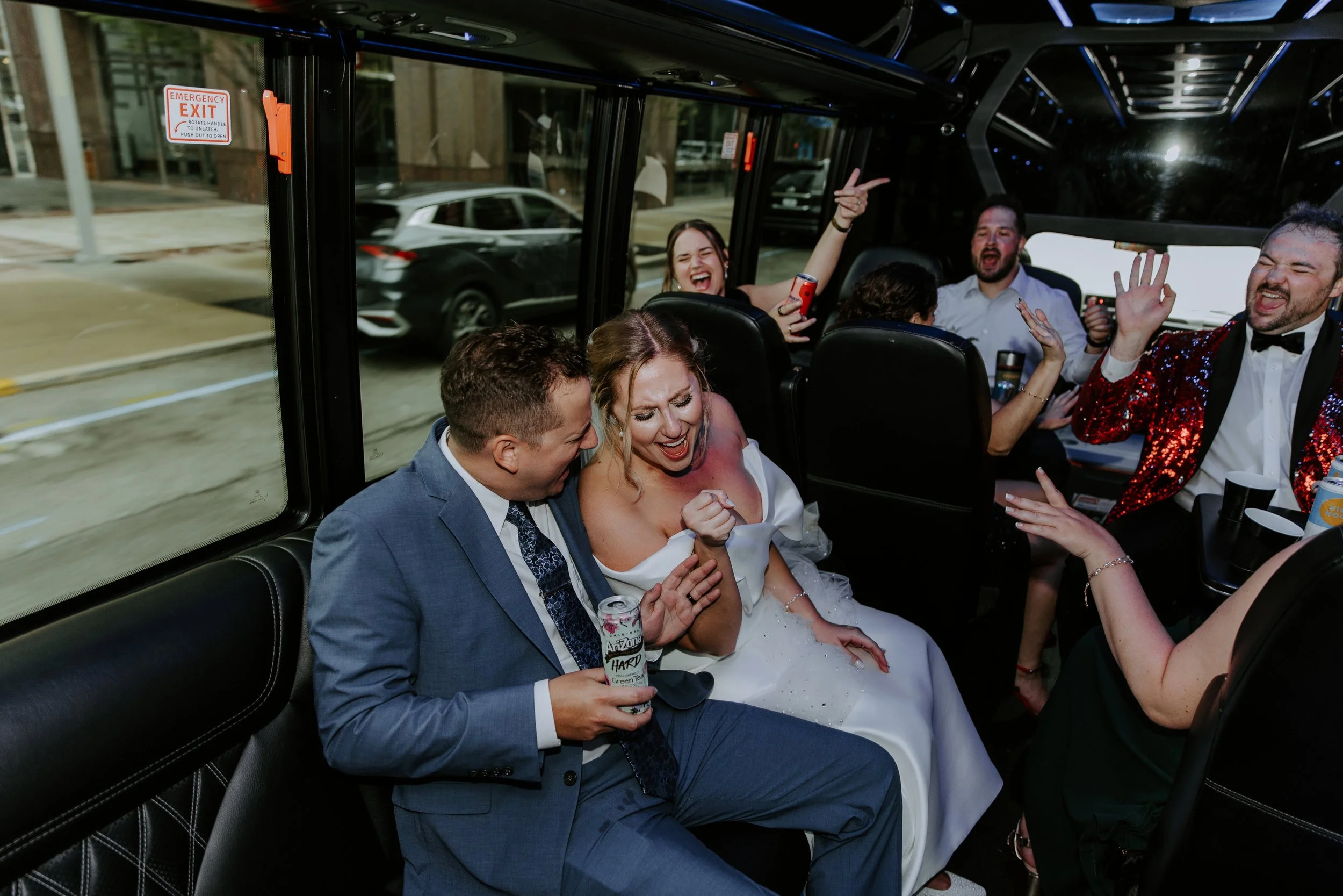 Bride and Groom are on a party bus with their friends singing along to music.