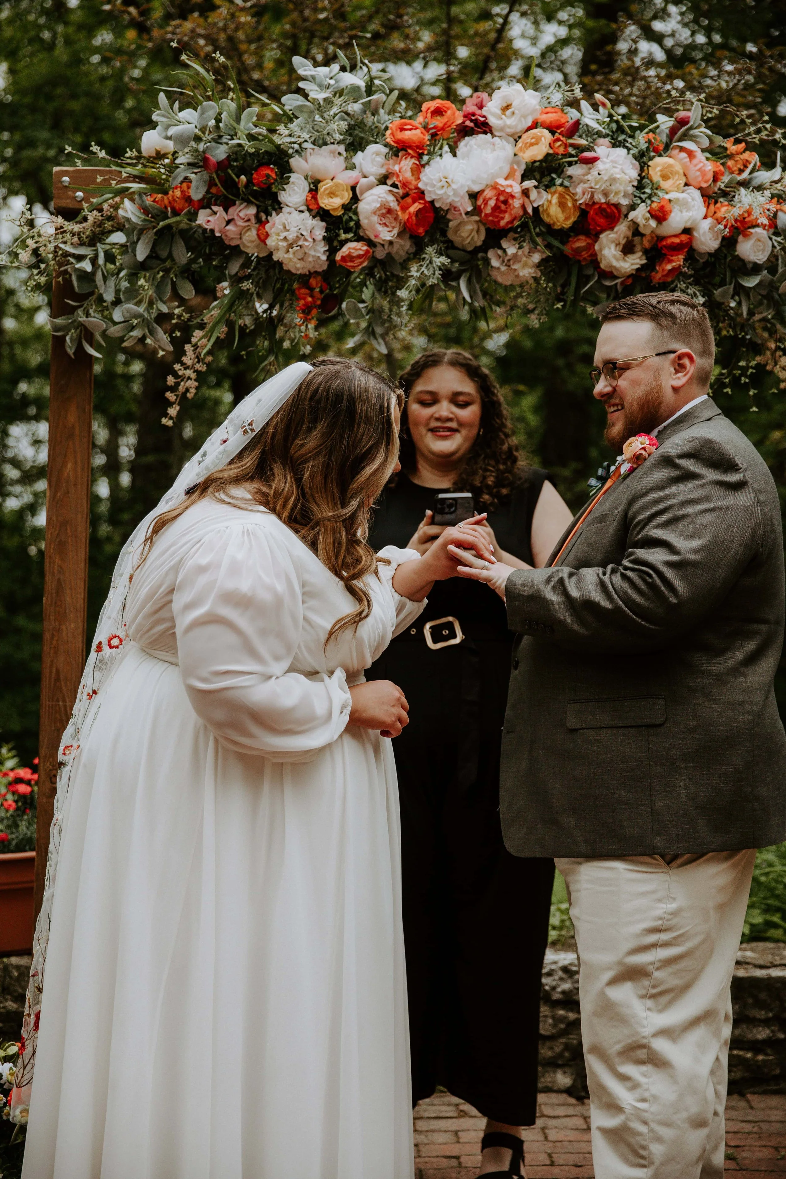 The bride puts the groom's ring on his finger.