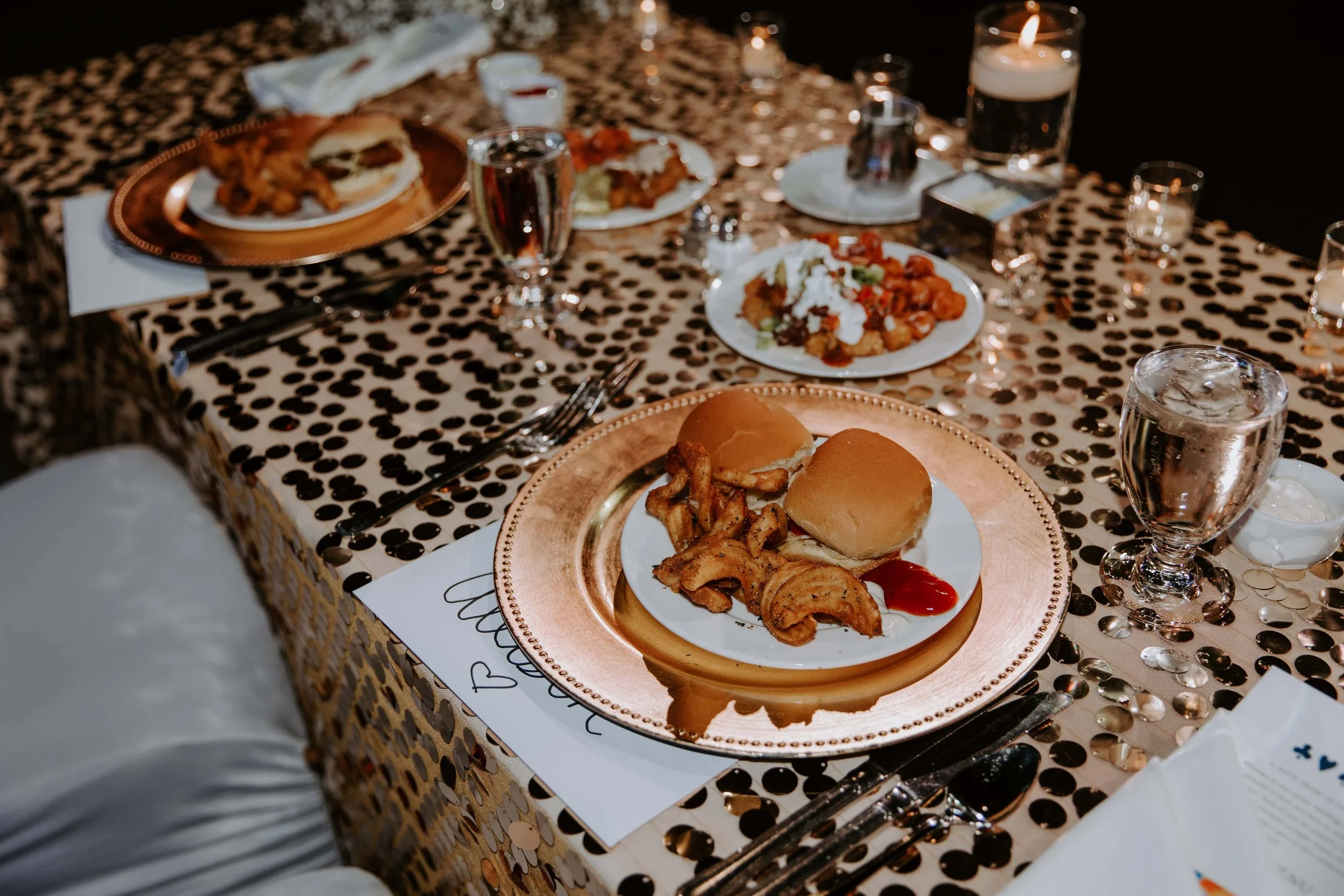 The head table filled with plates of food and drinks.