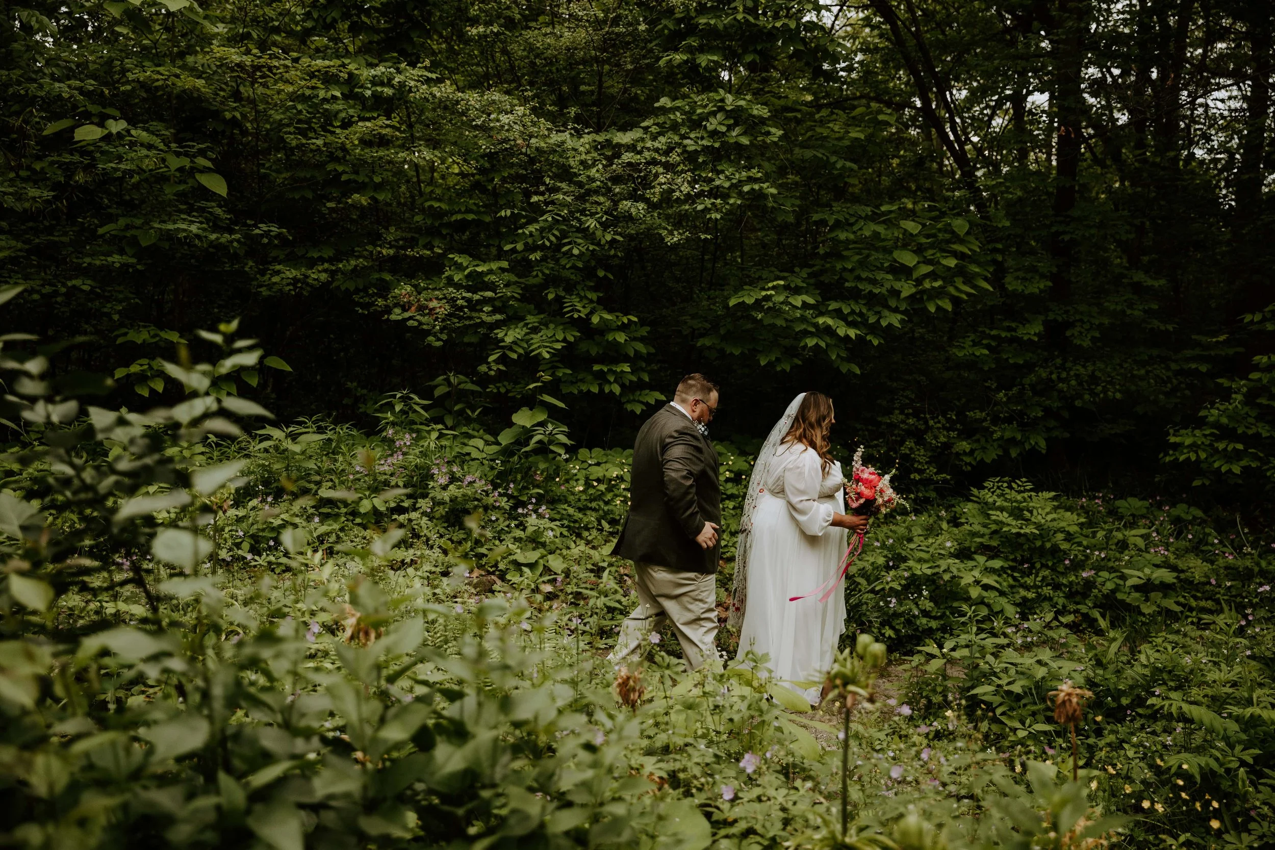 The bride and groom walk through the Sunken Gardens at Minnetrista.