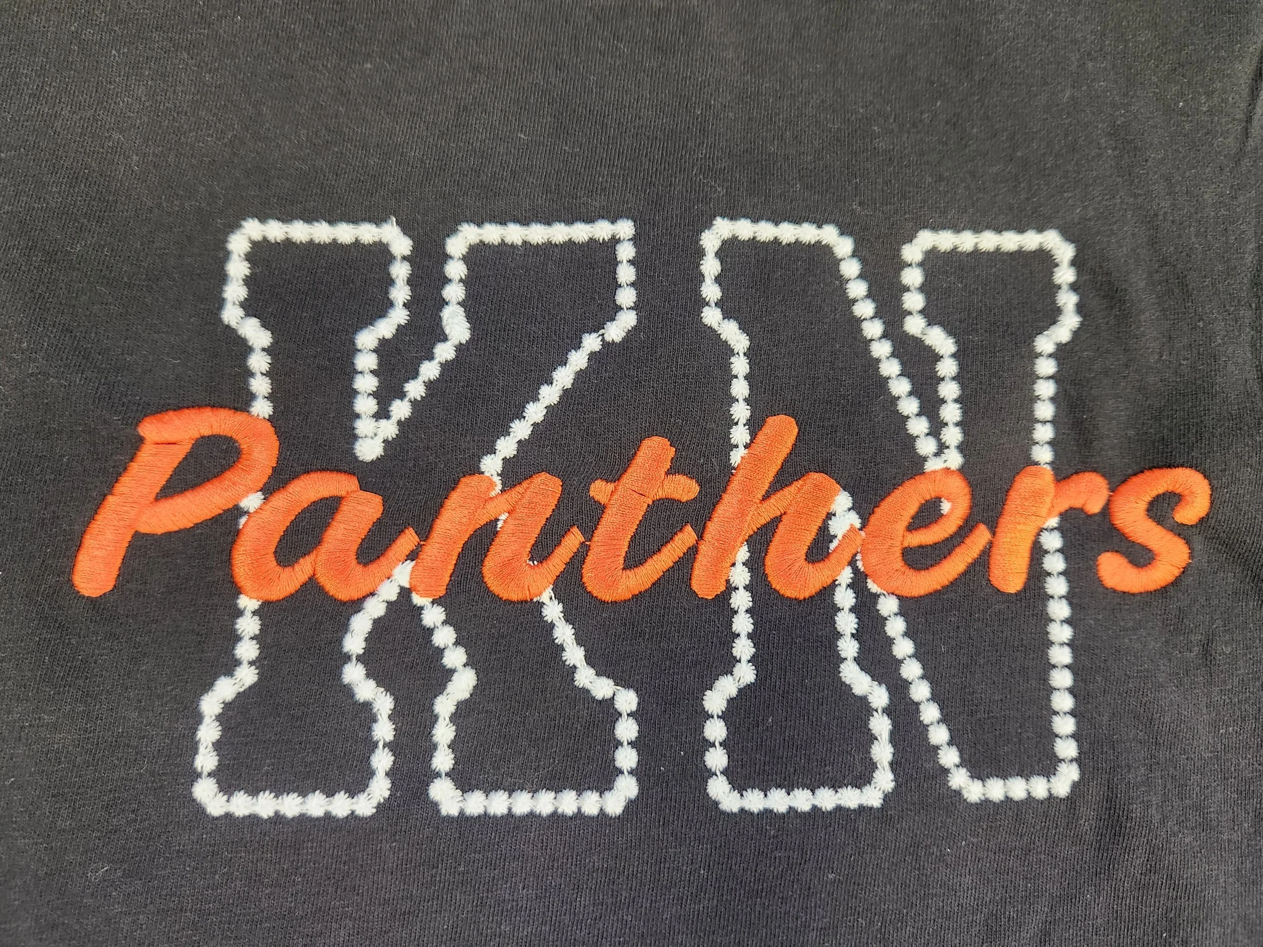 Embroidered KN Panthers Comfort Color T-Shirt, black t-shirt with letters K and N embroidered in white thread with Panthers embroidered on top of the letters in orange thread, Knob Noster Panthers