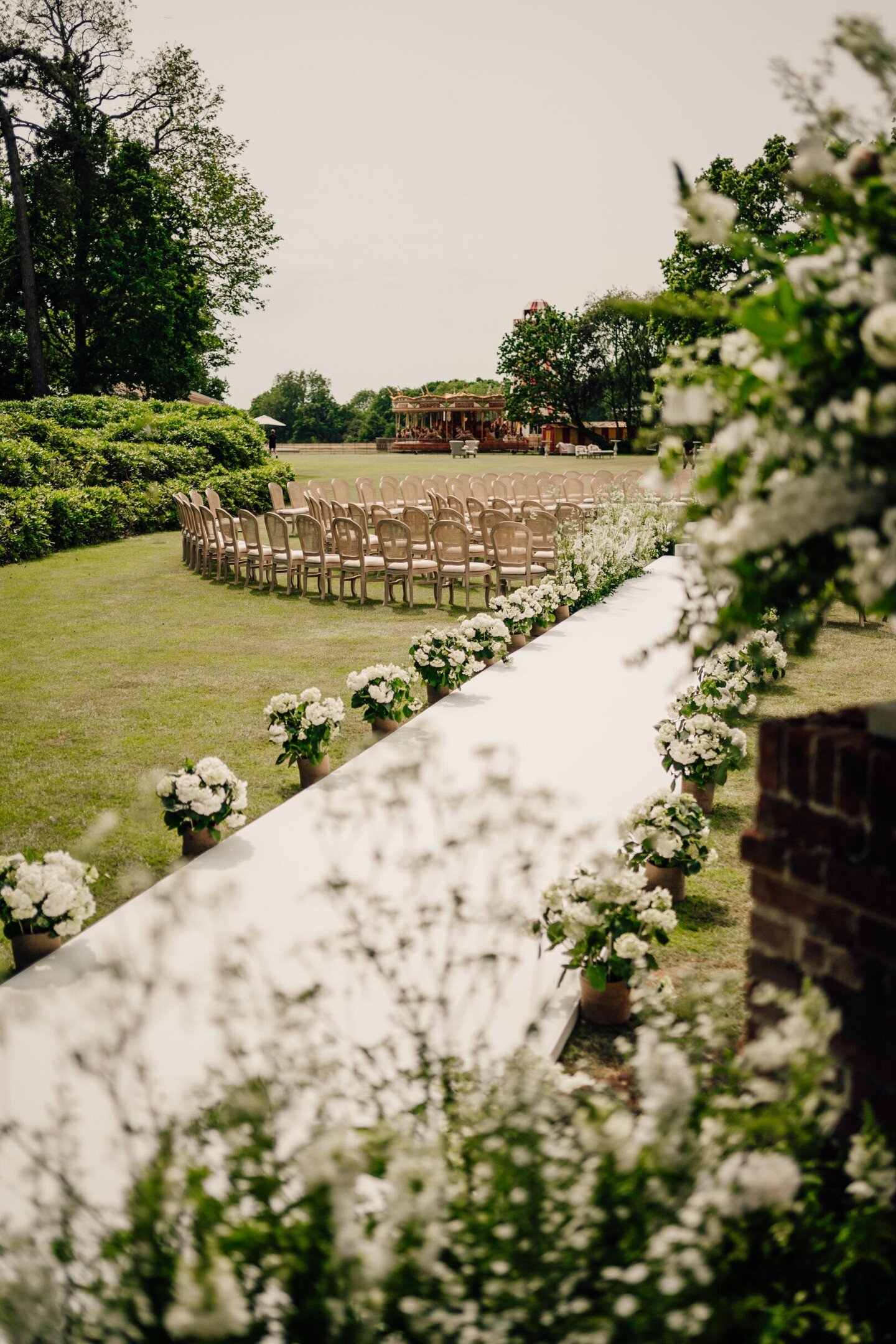 At A&amp;J's remarkable summer wedding, hosted at their family home last summer, the scene was set for an unforgettable ceremony. The aisle, adorned with blooms of white and greenery, guided guests to an elegant spiral formation of Elliana chairs. Ag