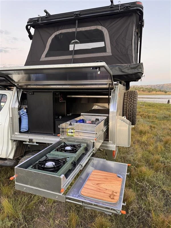 Rooftop camper kitchen setup with fridge and utensils for hire