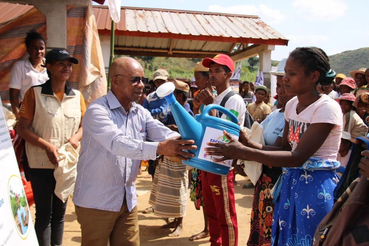 Marceline receiving a watering can at the Fagnimbogna 'World Food Day' celebration