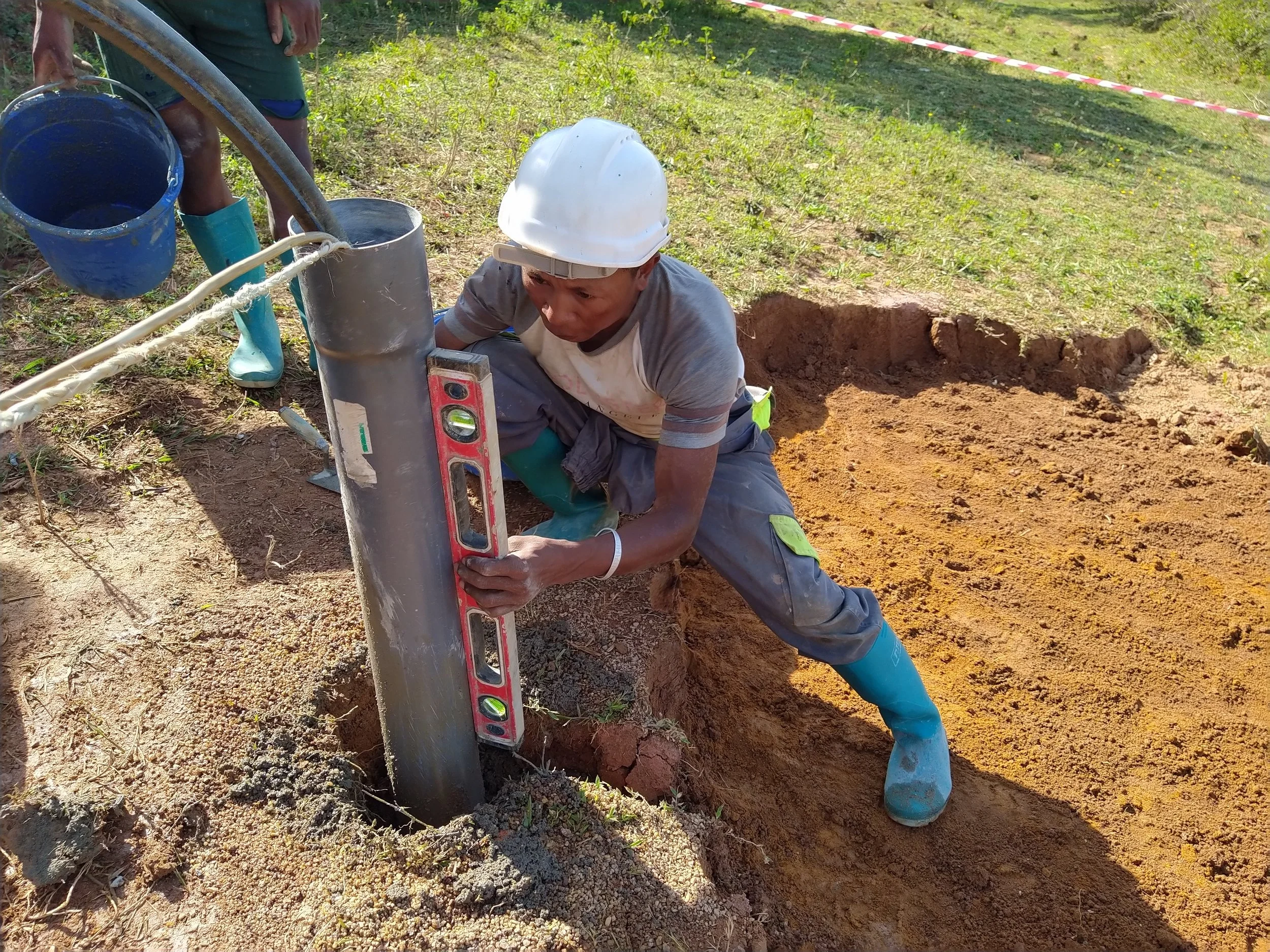 Lowering the PVC pipe into the ground