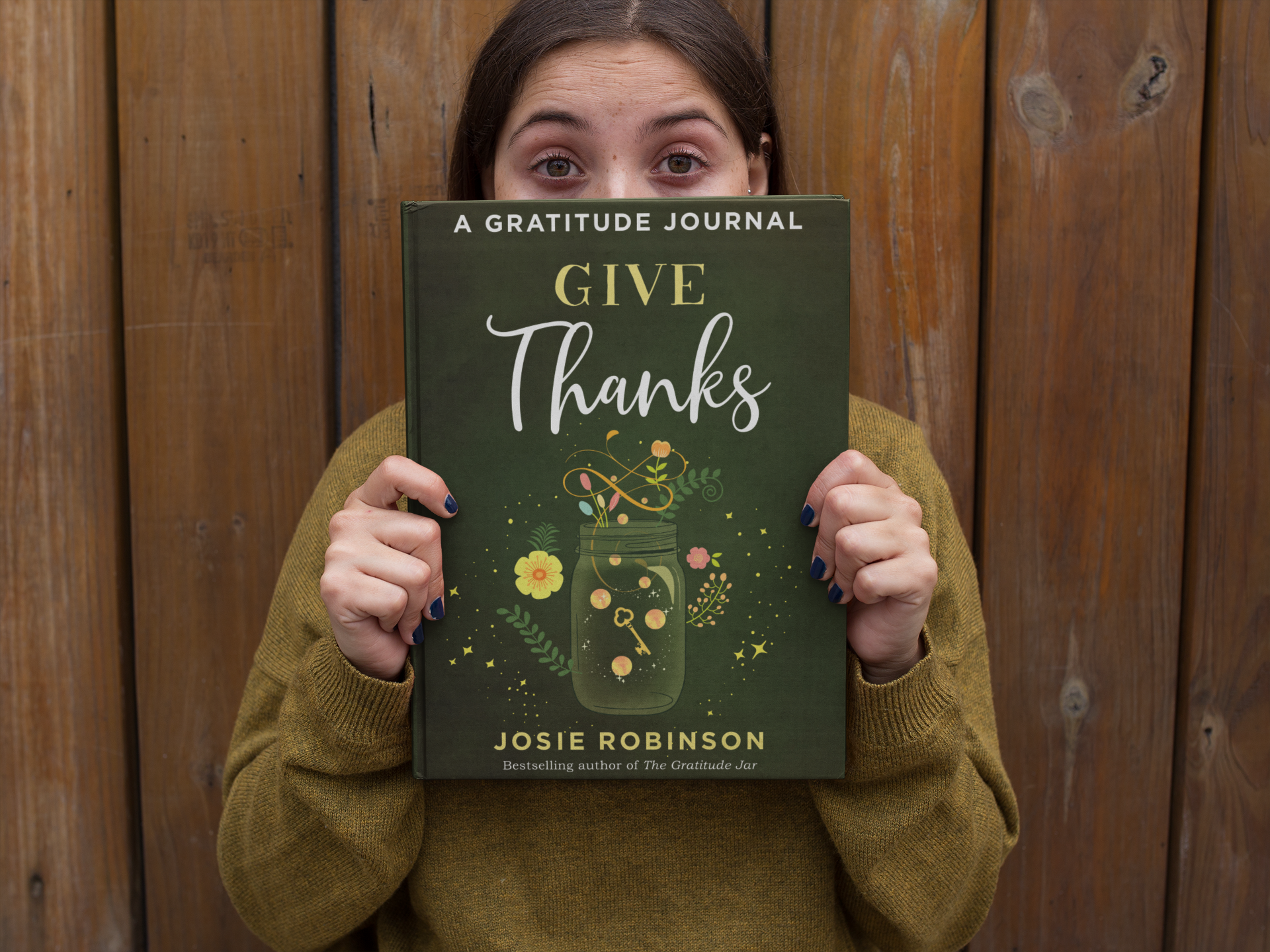 A woman holding a copy of Give Thanks: A Gratitude Journal by Josie Robinson