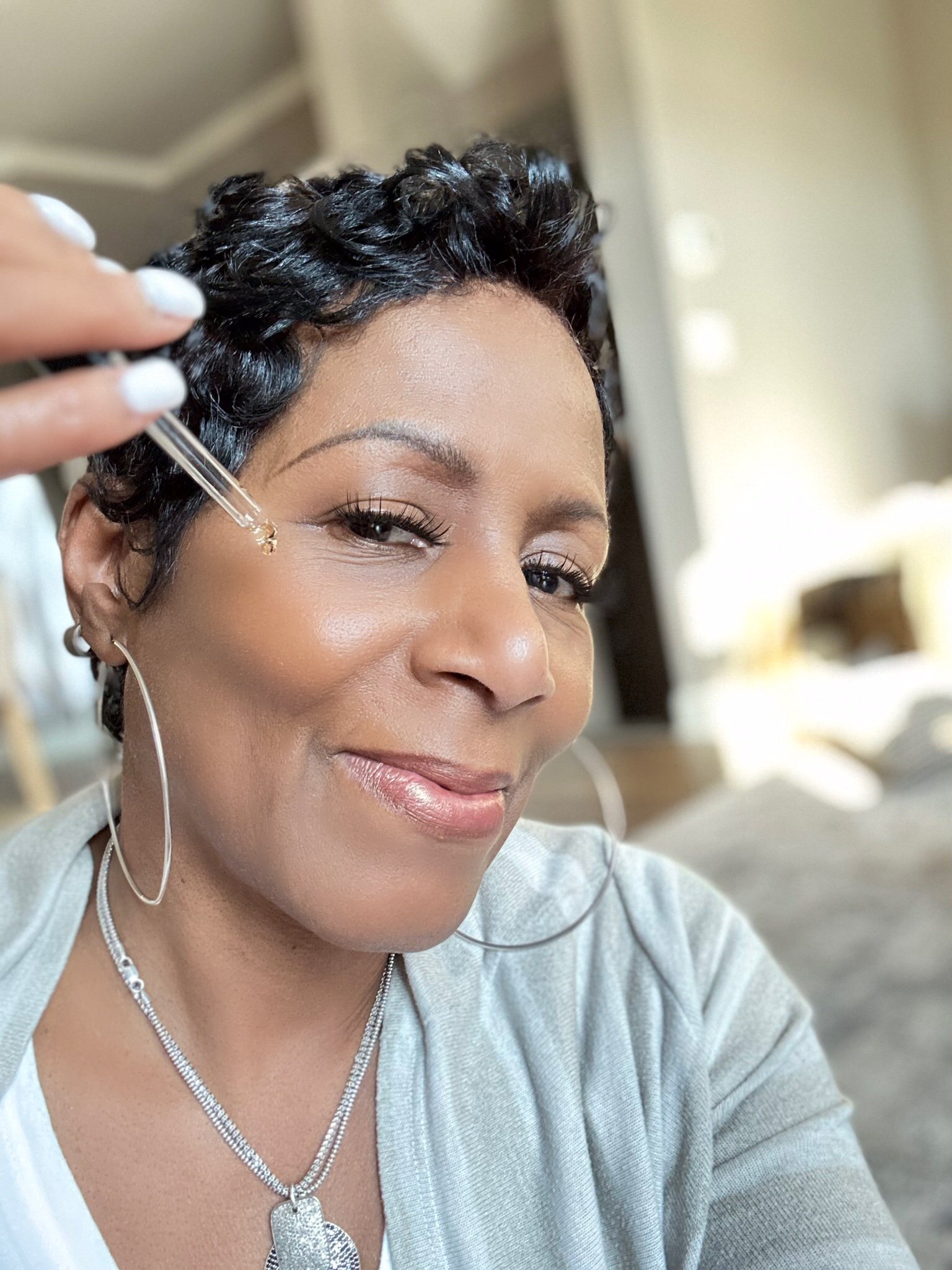 a model holding a dropper near her chic with hyaluronic acid