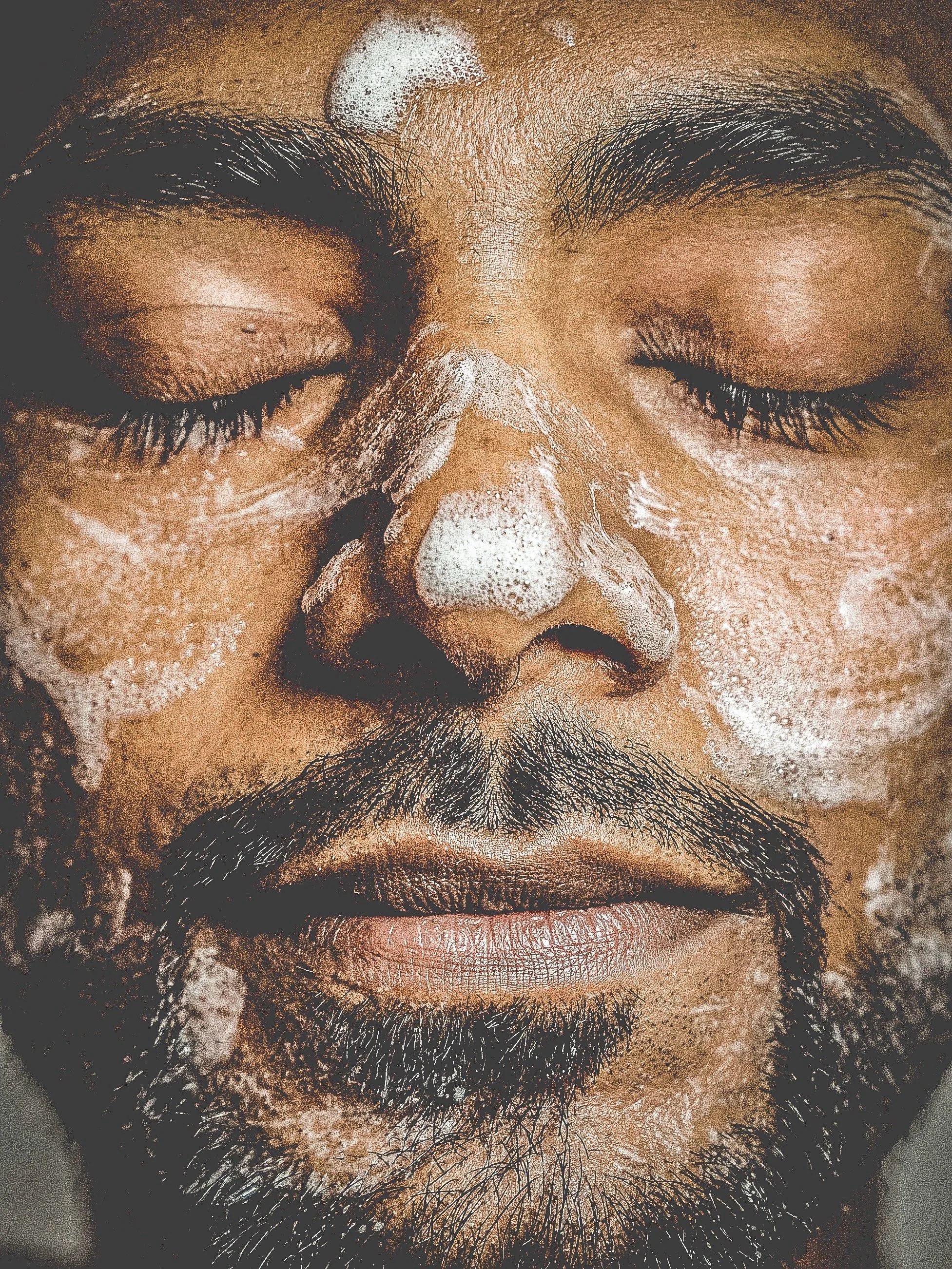 A black man with facial cleansing foam on his face