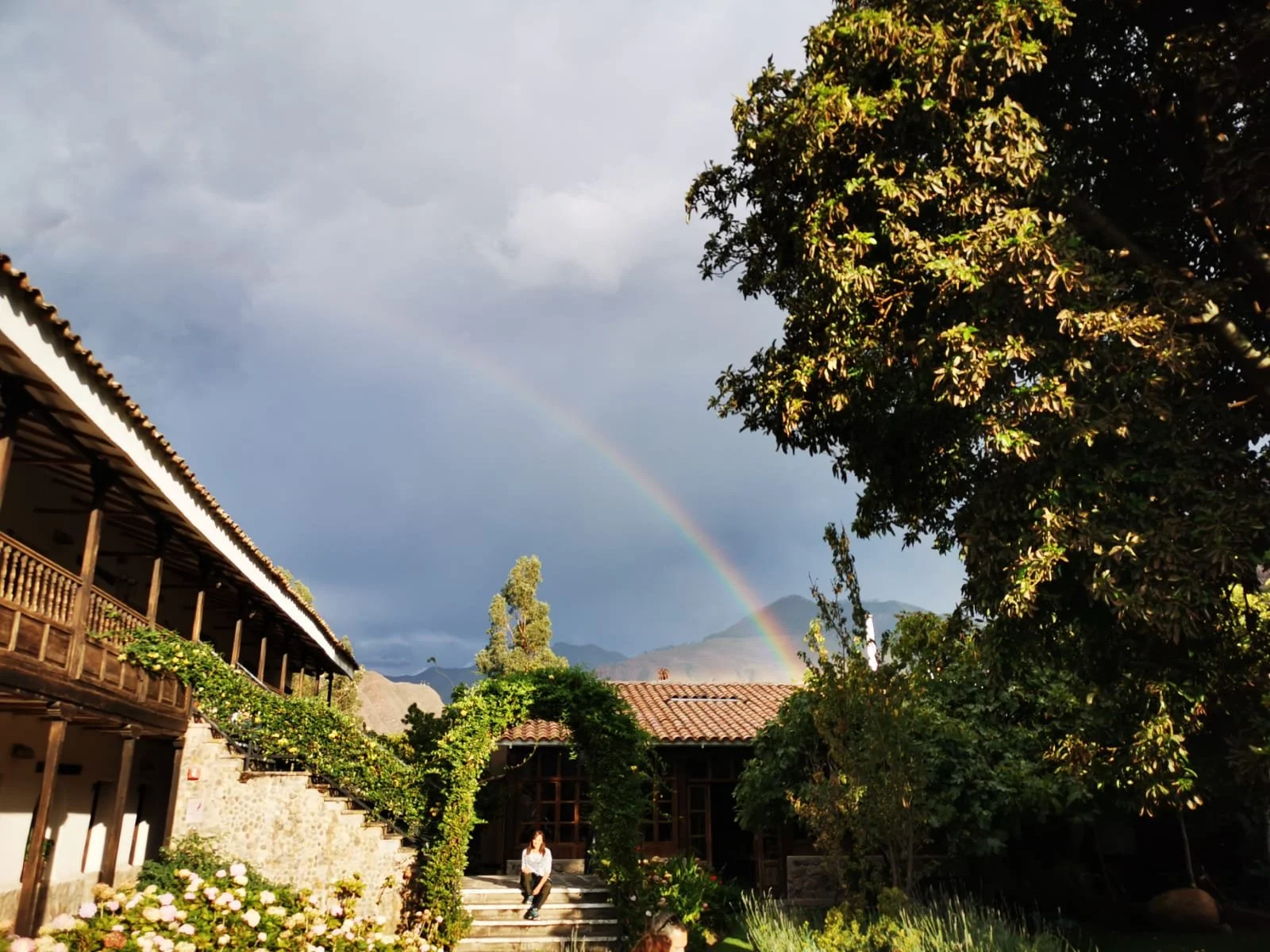 Sitting on steps under rainbow in Sacred Valley