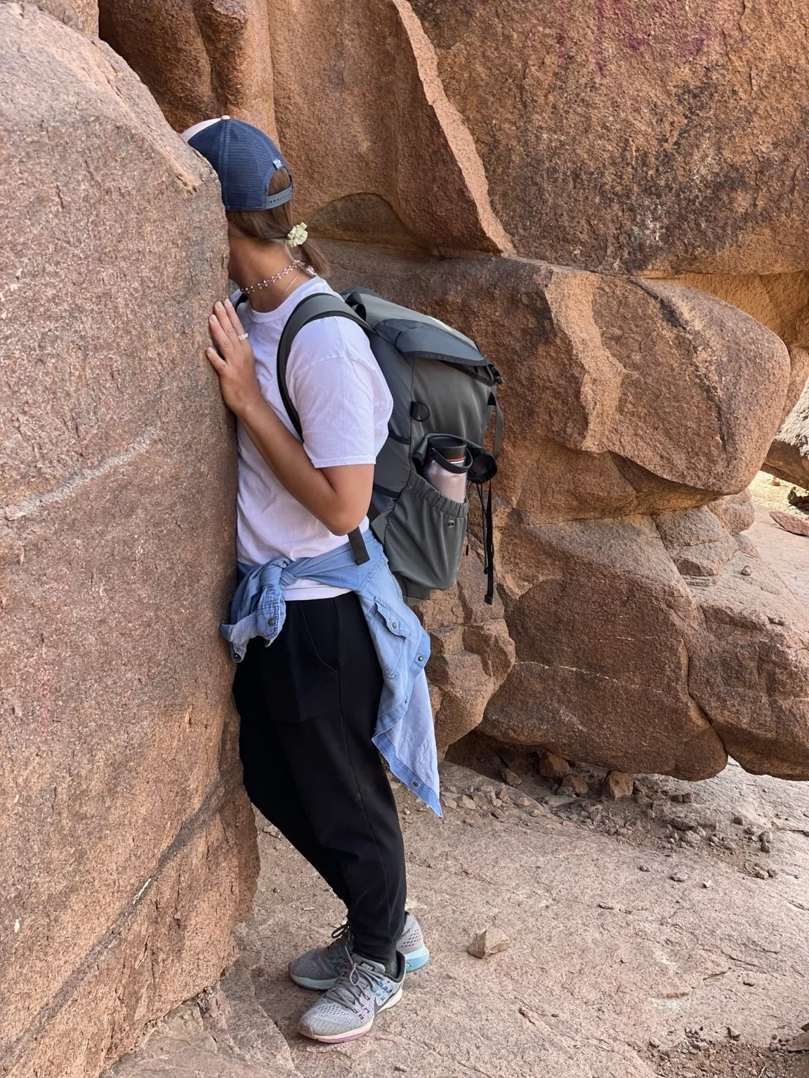 Tonia Johnson pausing beside red-rock formations during a hike.