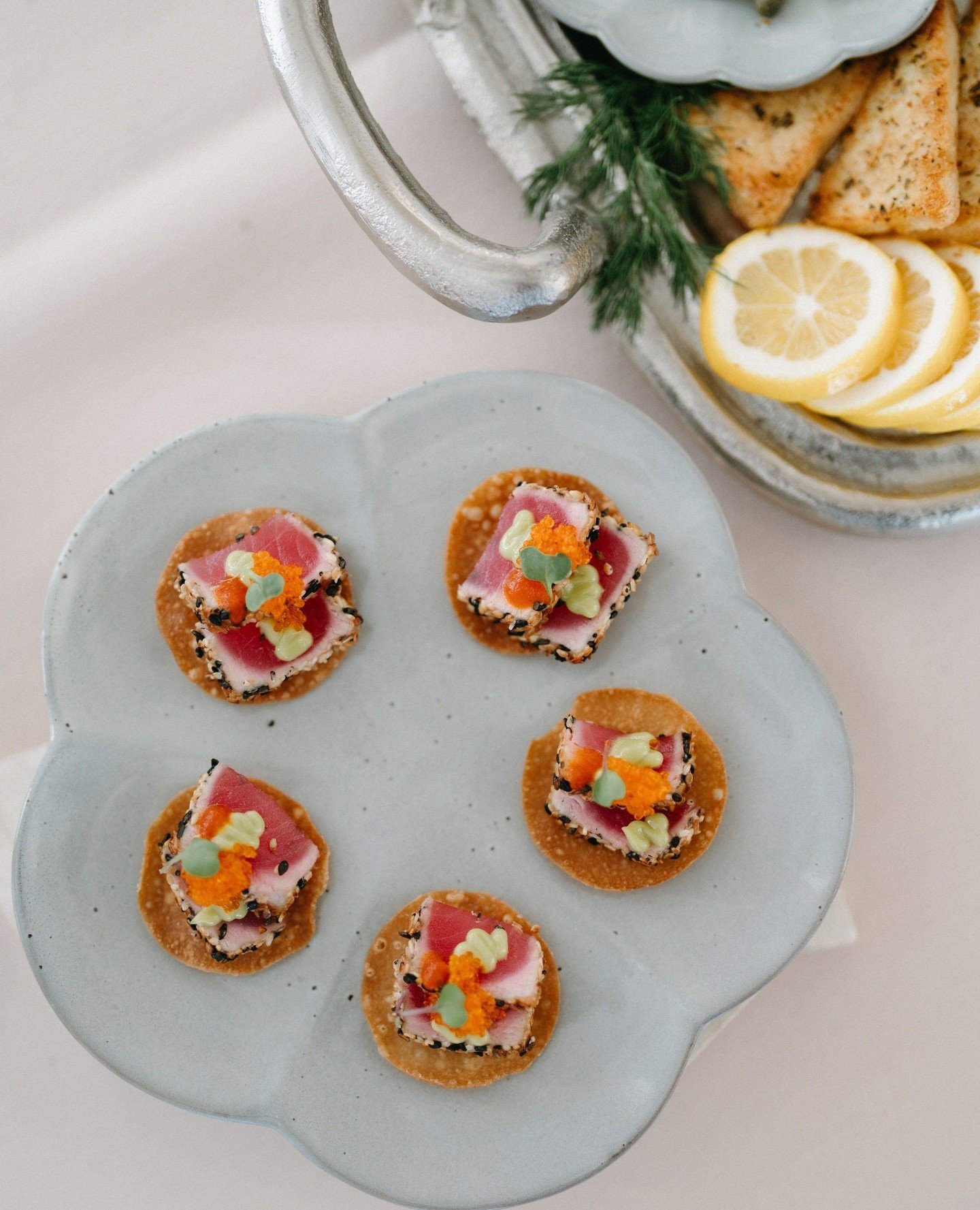 Bite sized deliciousness- a wonton chip topped with flavorful black sesame seared tuna, zesty wasabi aioli, crunchy tobiko, and micro flowers 😋⁠
⁠
⁠
Design - @lunawilddesign⁠
Photo - @zoeisabelphotography⁠
drapery - @questevents_socal⁠
florals - @le