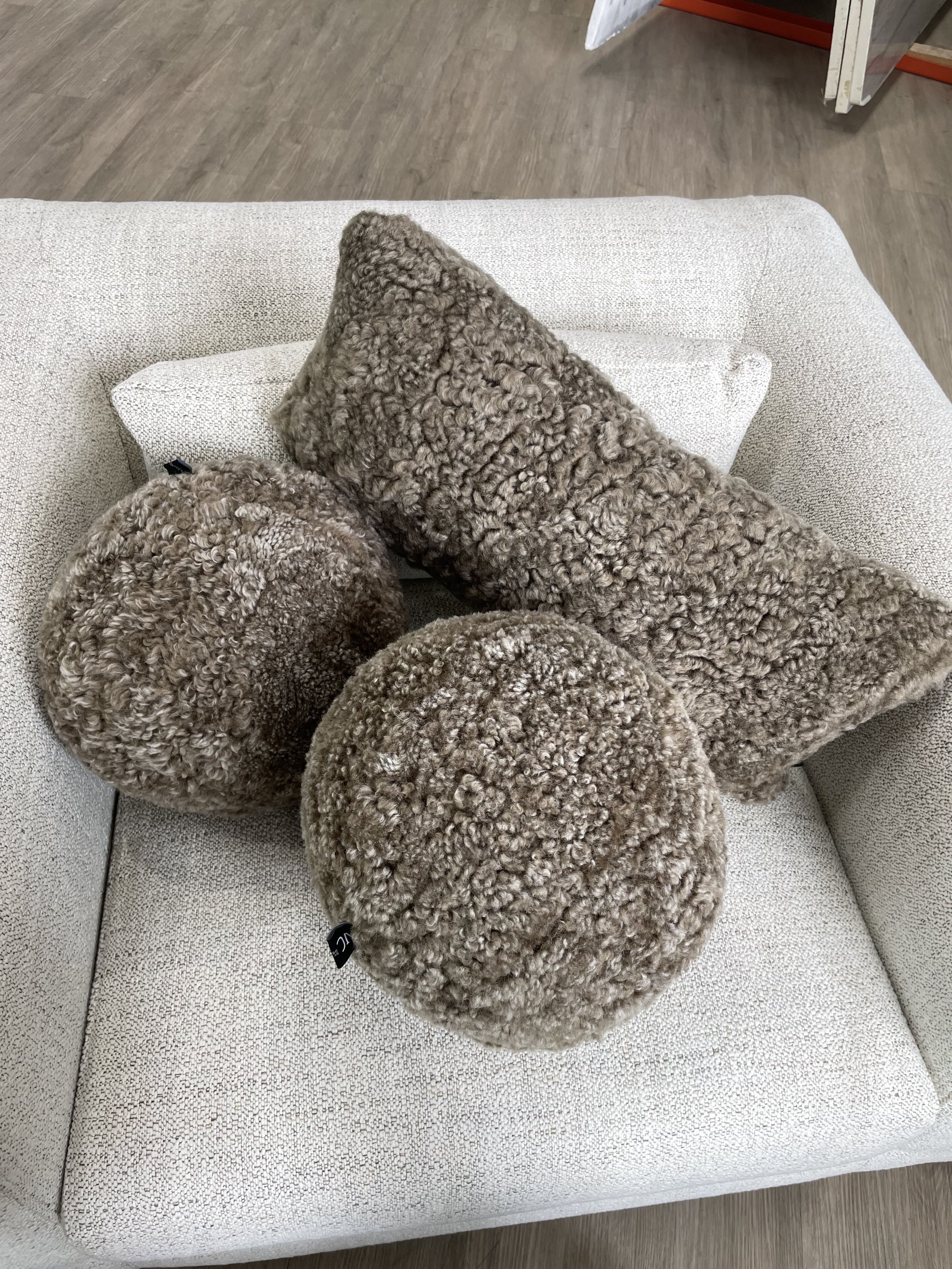 Pair of Crosby Sugar bouclé club chairs with walnut legs in Dallas showroom