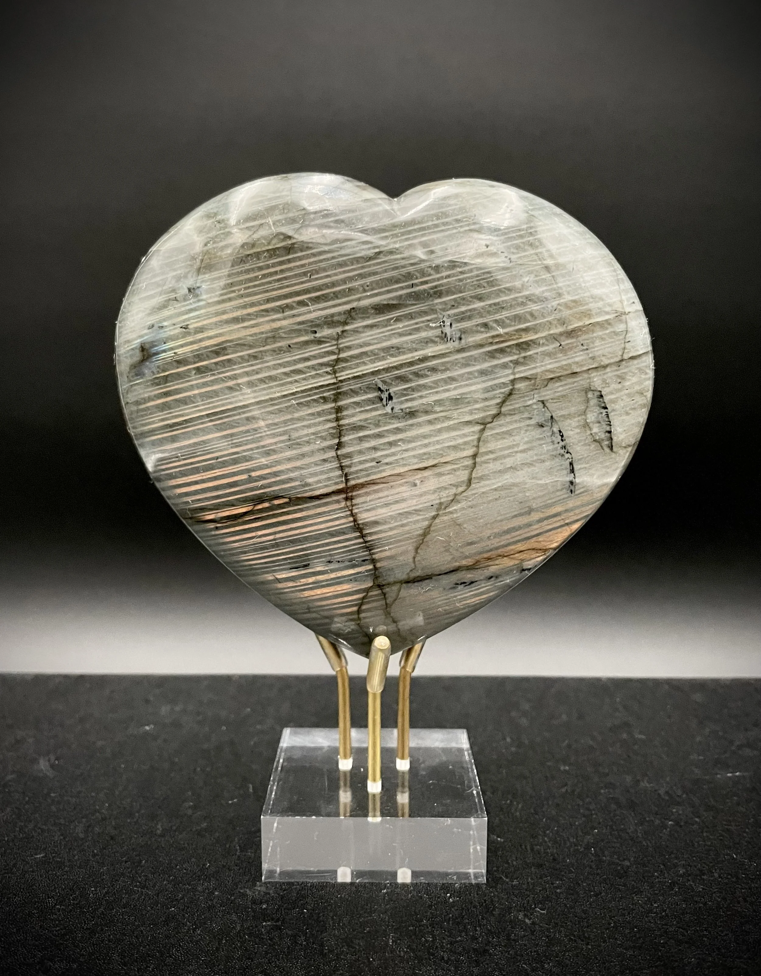 Iridescent labradorite heart on acrylic and brass stand, luxury crystal décor in Dallas showroom