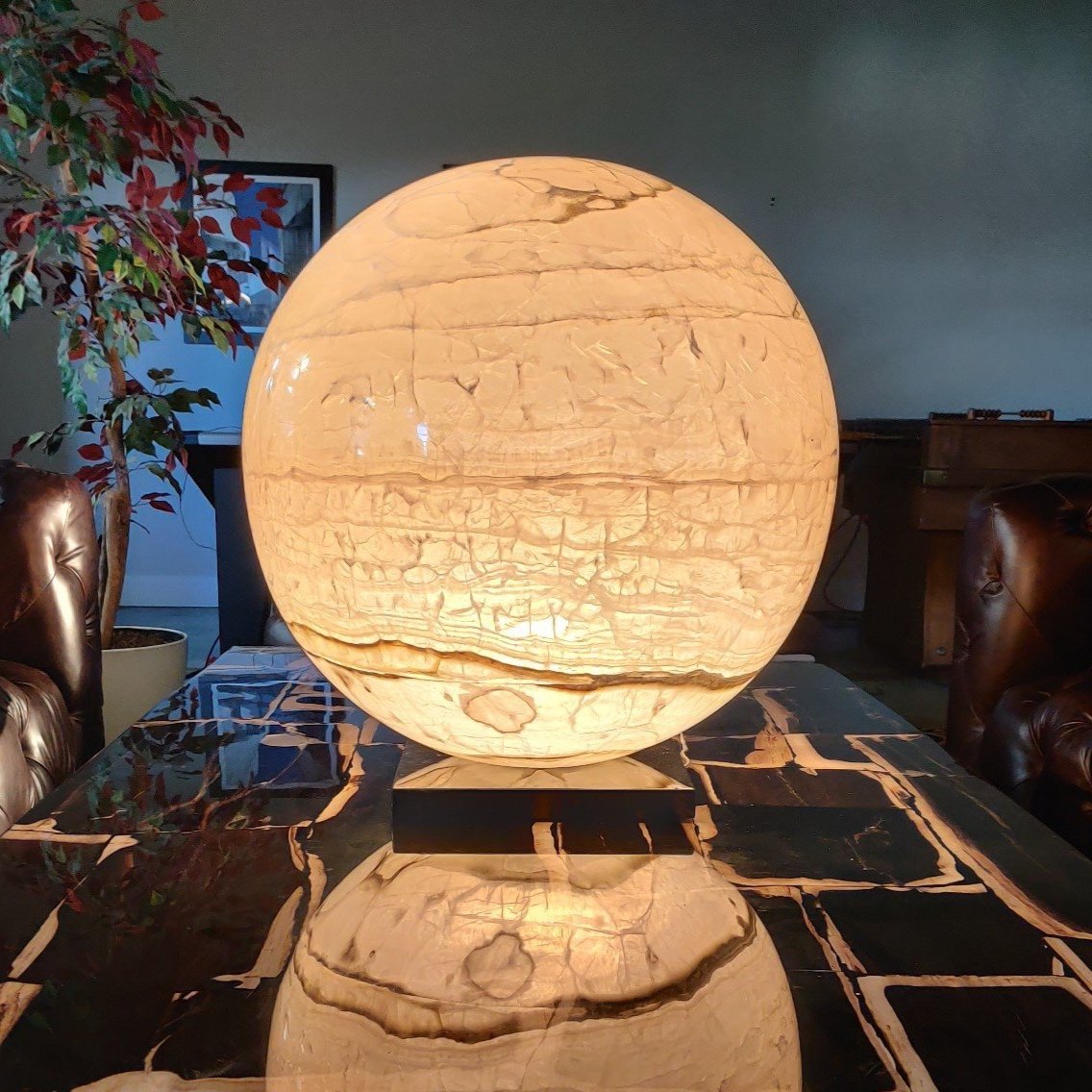 Glowing onyx sphere lamp on black stone table in a modern Dallas interior