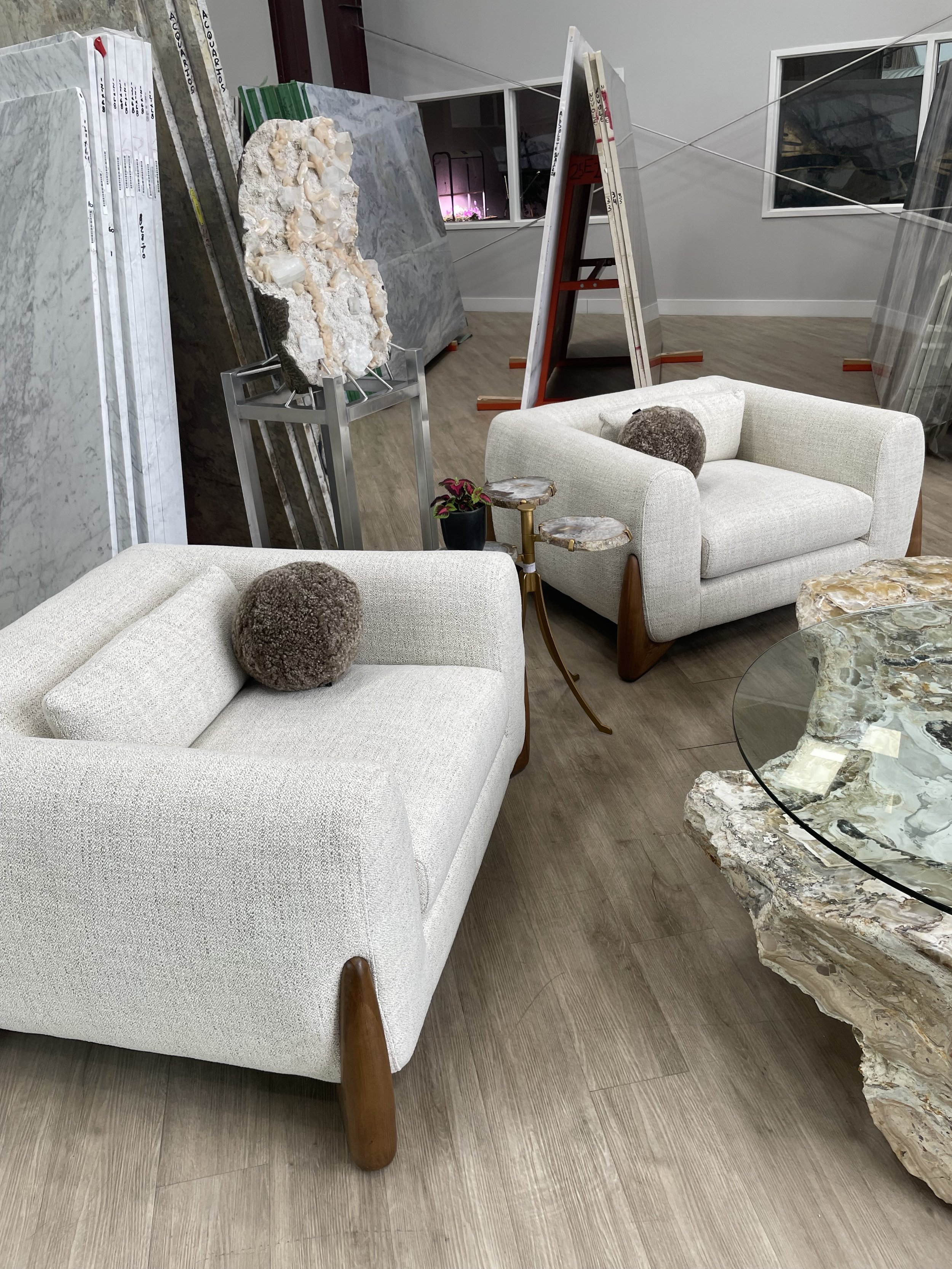 Pair of Crosby Sugar bouclé club chairs with walnut legs in Dallas showroom