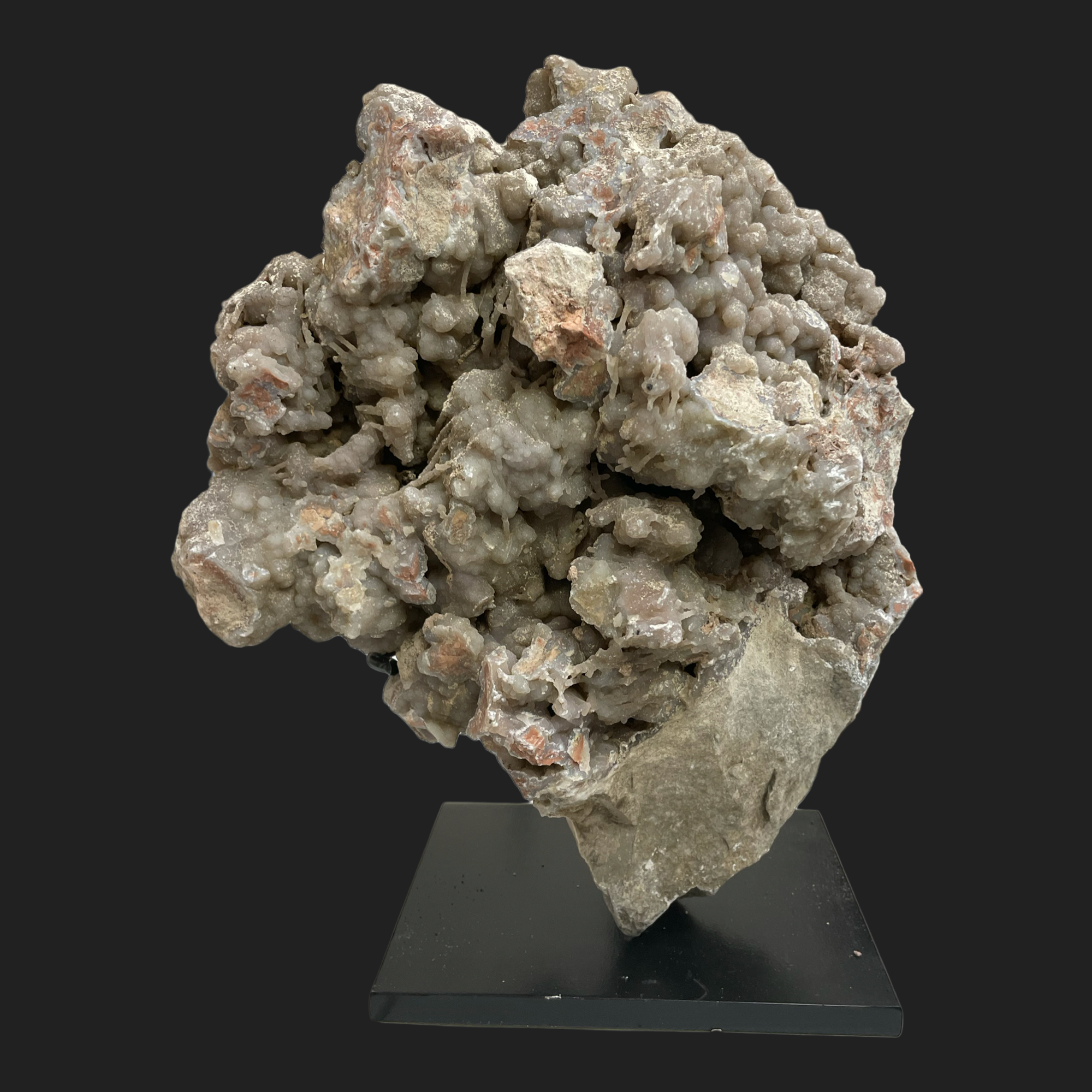 Mounted Wyoming youngite jasper cluster showing pink-tan breccia and UV-reactive agate