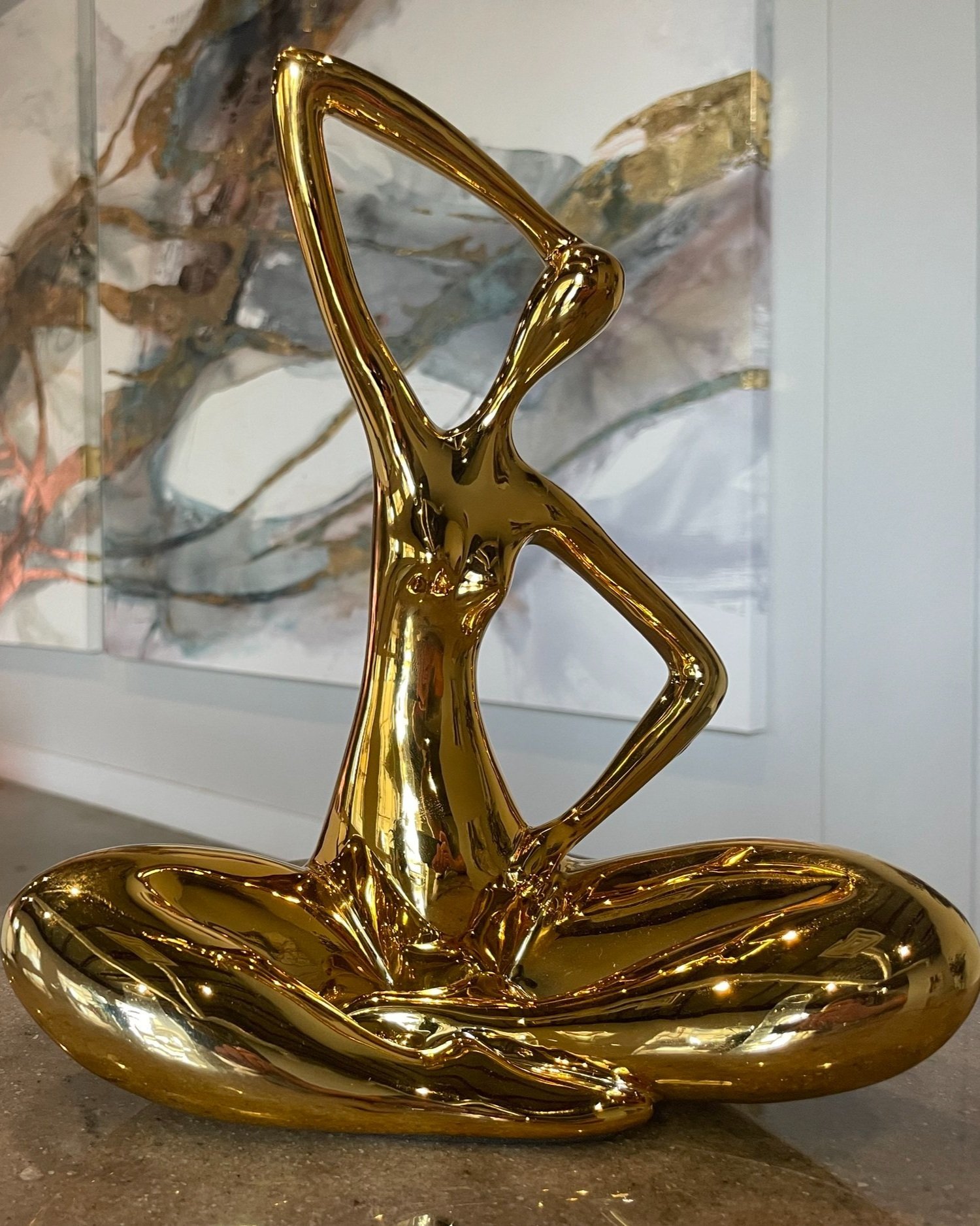 Polished gold modern yoga sculpture on display shelf