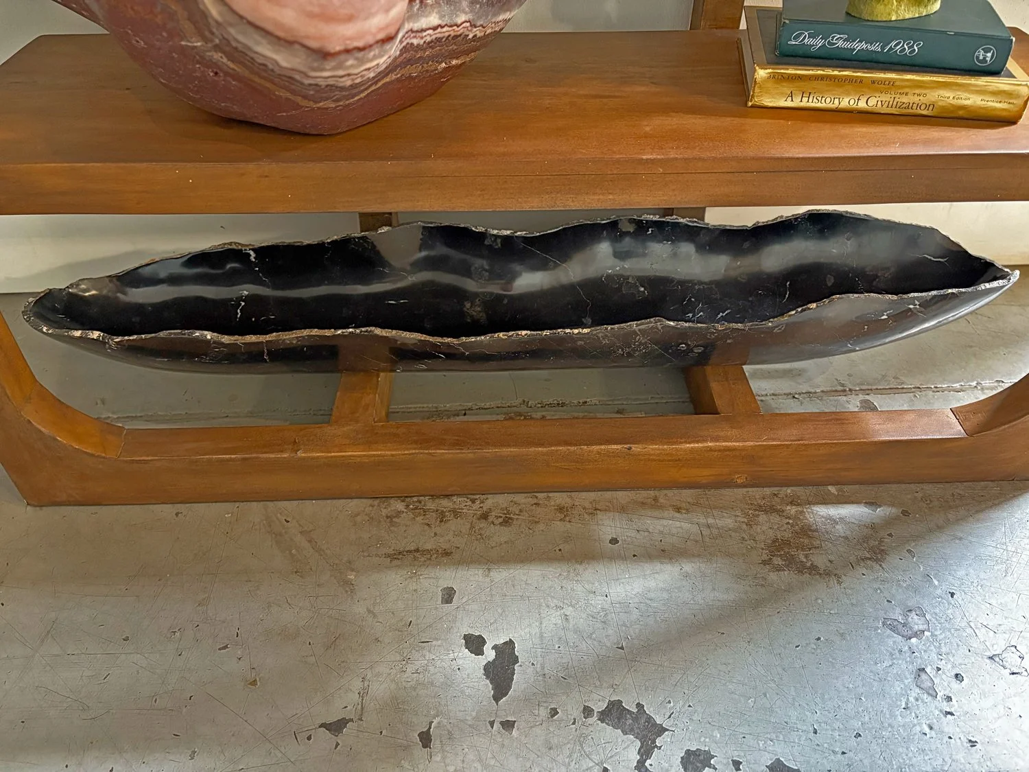 Hand-carved black onyx bowl with organic silhouette and fossil inclusions