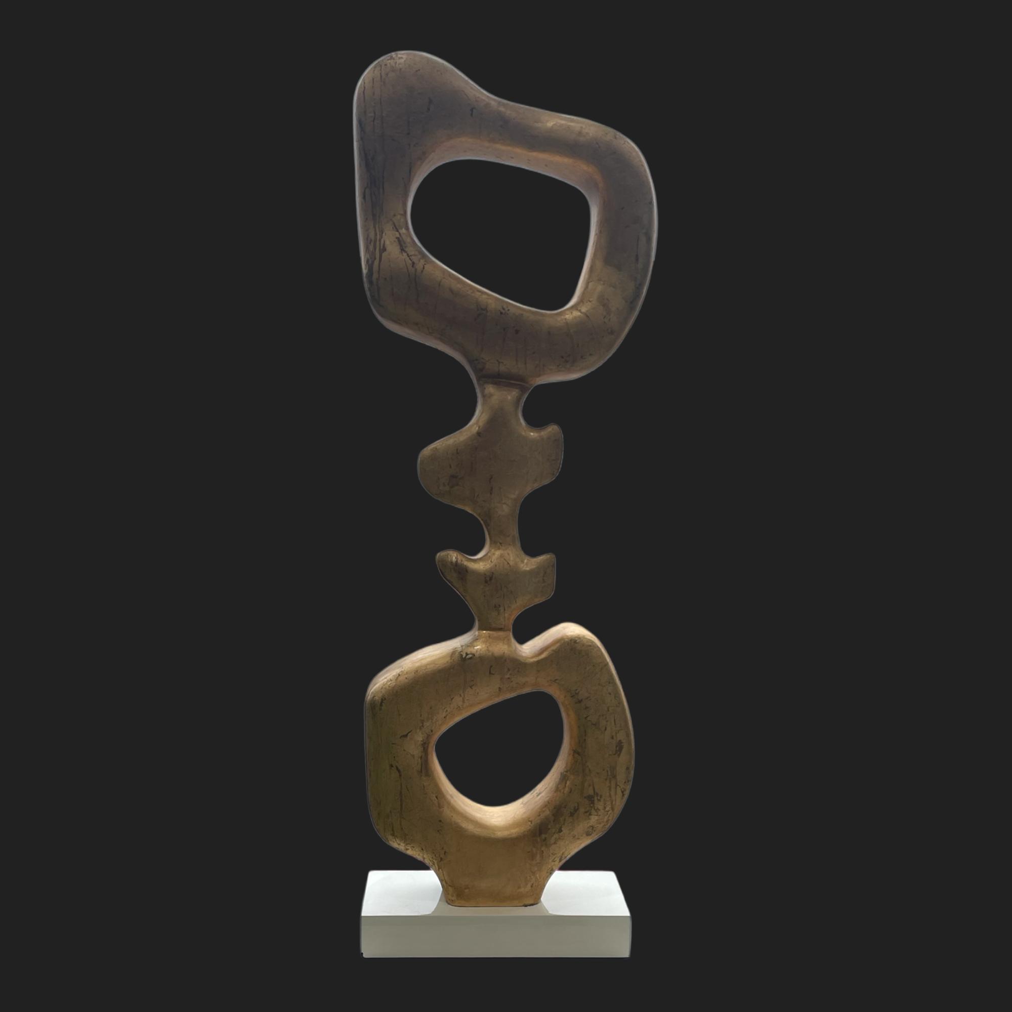 Abstract gold ribbon sculpture on white base, modern home décor accent