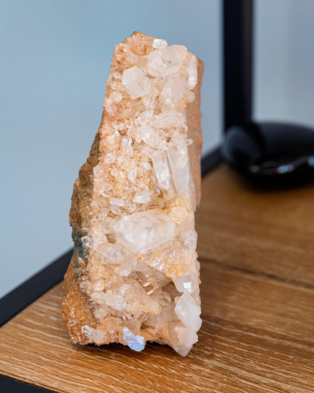 all natural phantom selenite specimen standing on wood surface with visible clarity and structure
