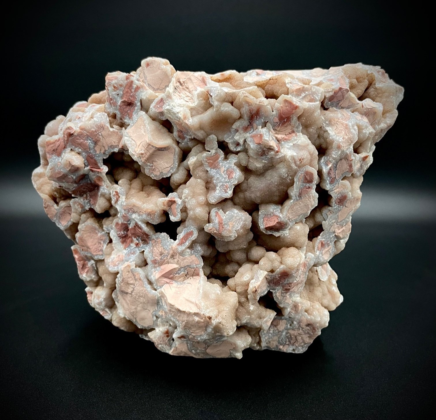 Mounted Wyoming youngite jasper cluster showing pink-tan breccia and UV-reactive agate