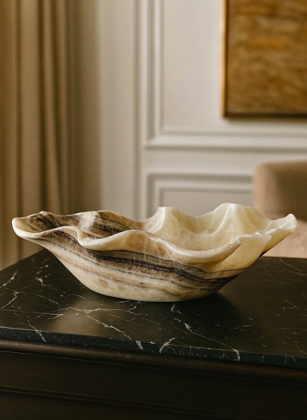 Ripple-edged white and black onyx bowl on a black granite surface
