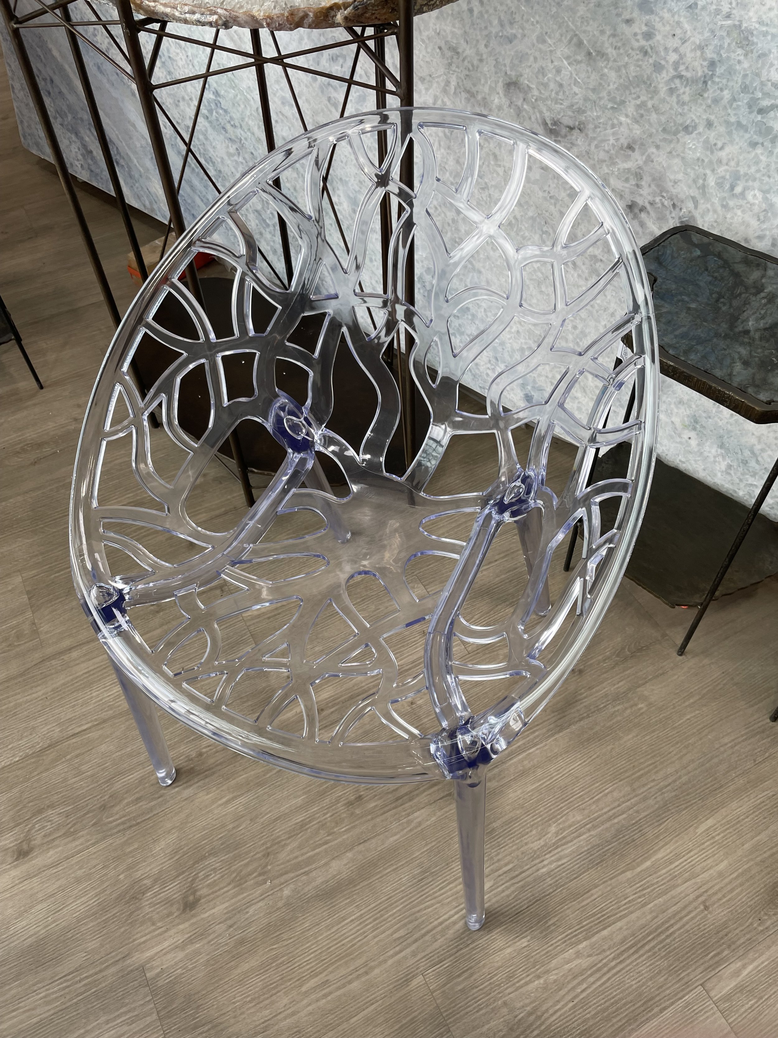 Transparent acrylic accent chair with branch-pattern backrest in modern living room