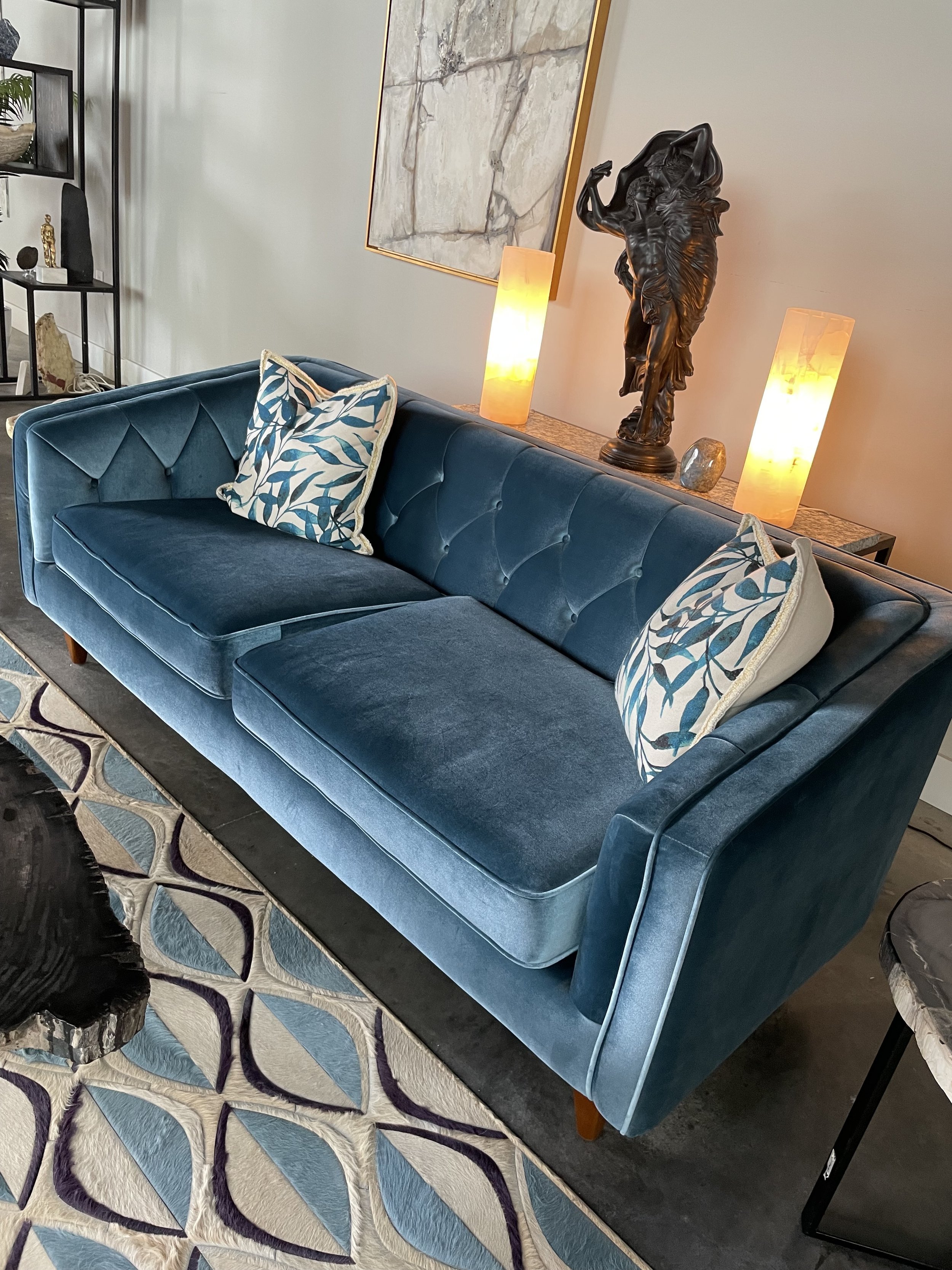Blue velvet tufted sofa with walnut legs in modern living room