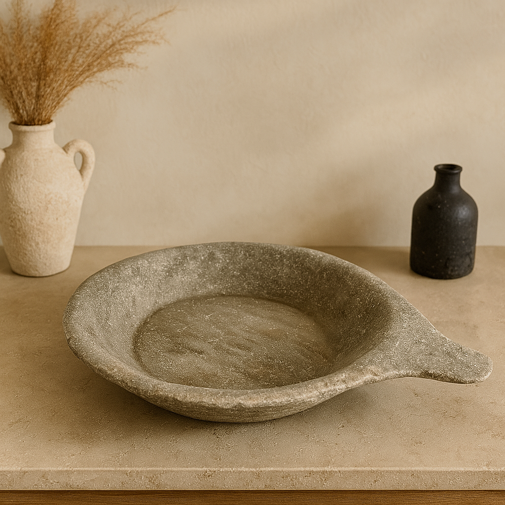 Hand-carved gray river-stone display tray with natural handle, styled on a console