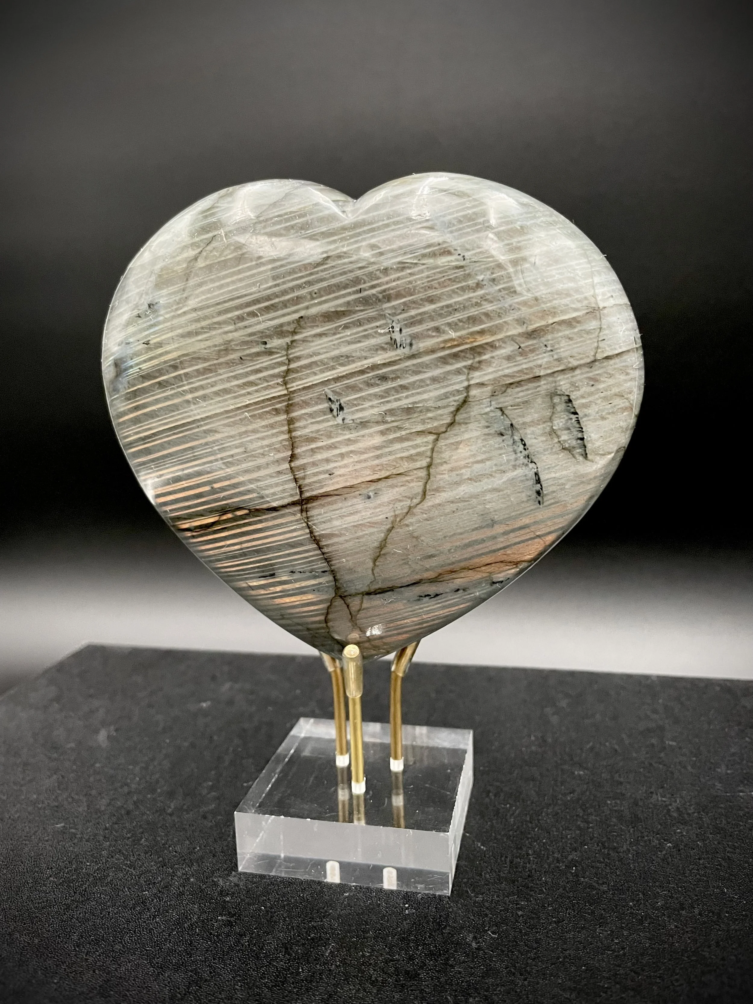 Iridescent labradorite heart on acrylic and brass stand, luxury crystal décor in Dallas showroom
